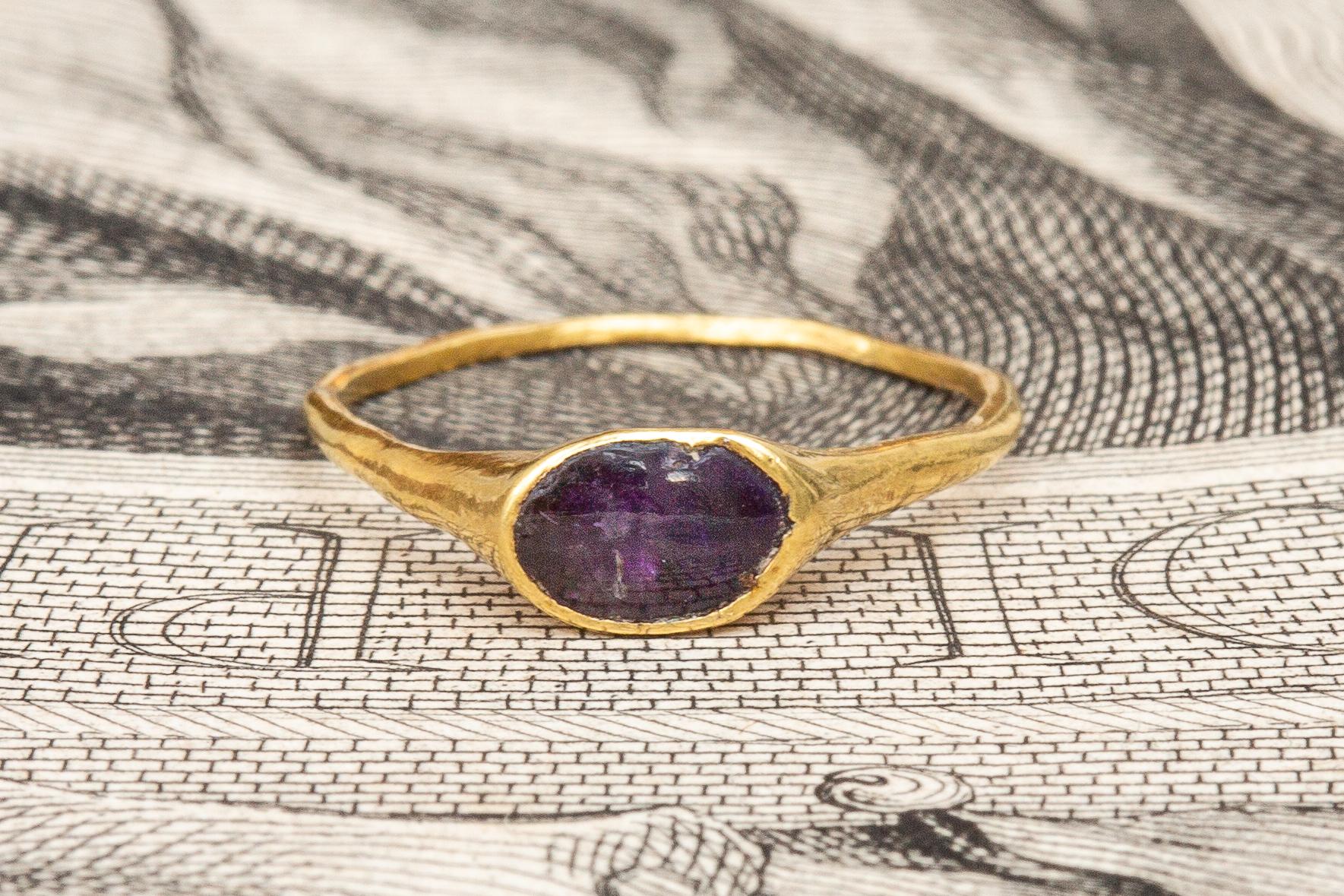 A very small but enchanting Medieval ring set with an amethyst dating to circa 1300! The high carat gold hoop extends outwards at the bezel into a distinctive medieval finger-ring shape, named by Victorian collectors as a ‘stirrup ring’ (due to the