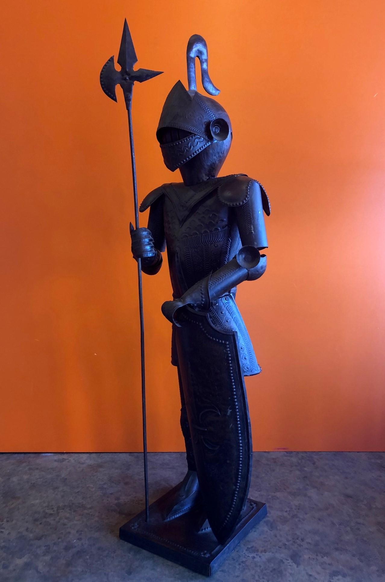 A very cool medieval armoured knight statue with embossed shield and battle ax, circa 1970s. The piece is made of metal and measures 23.5