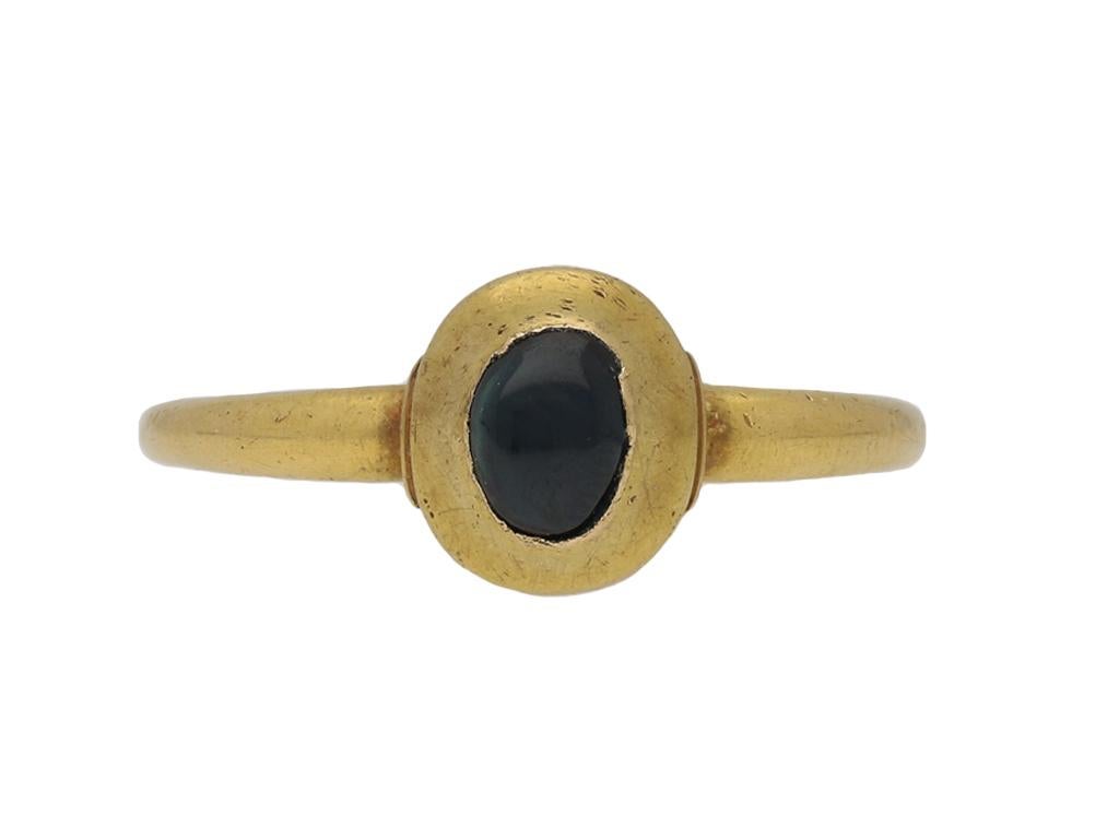 Medieval cabochon sapphire ring. Centrally set with an oval cabochon natural unenhanced sapphire in a closed back rubover setting with an approximate weight of 1.50 carats, to a raised oval collet with polished borders and champfered edge, flanked