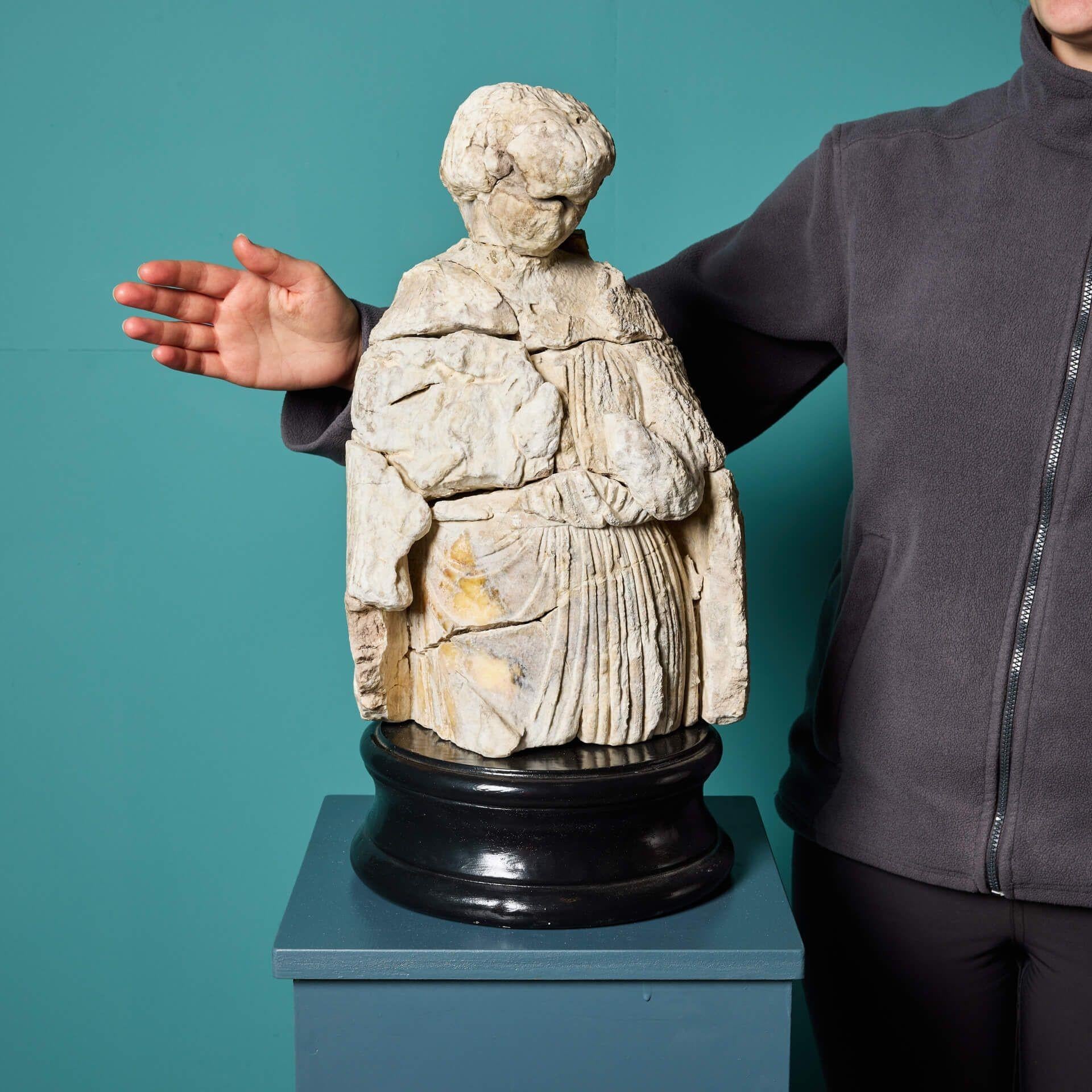 A medieval English alabaster statue, possibly dating as far back as the late 14th / early 15th century, mounted on one of our exclusive large display plinths. Well weathered over the centuries, this 600-year-old statue depicts a medieval cloaked