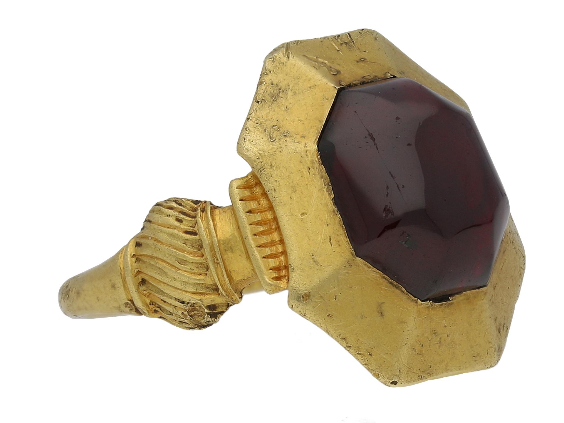 Medieval garnet cabochon ring. Set to centre with a single octagonal cabochon natural unenhanced garnet in a closed back rubover setting with an approximate weight of 8.00 carats, to an octagonal 'pie-dish' bezel design, leading to intricately