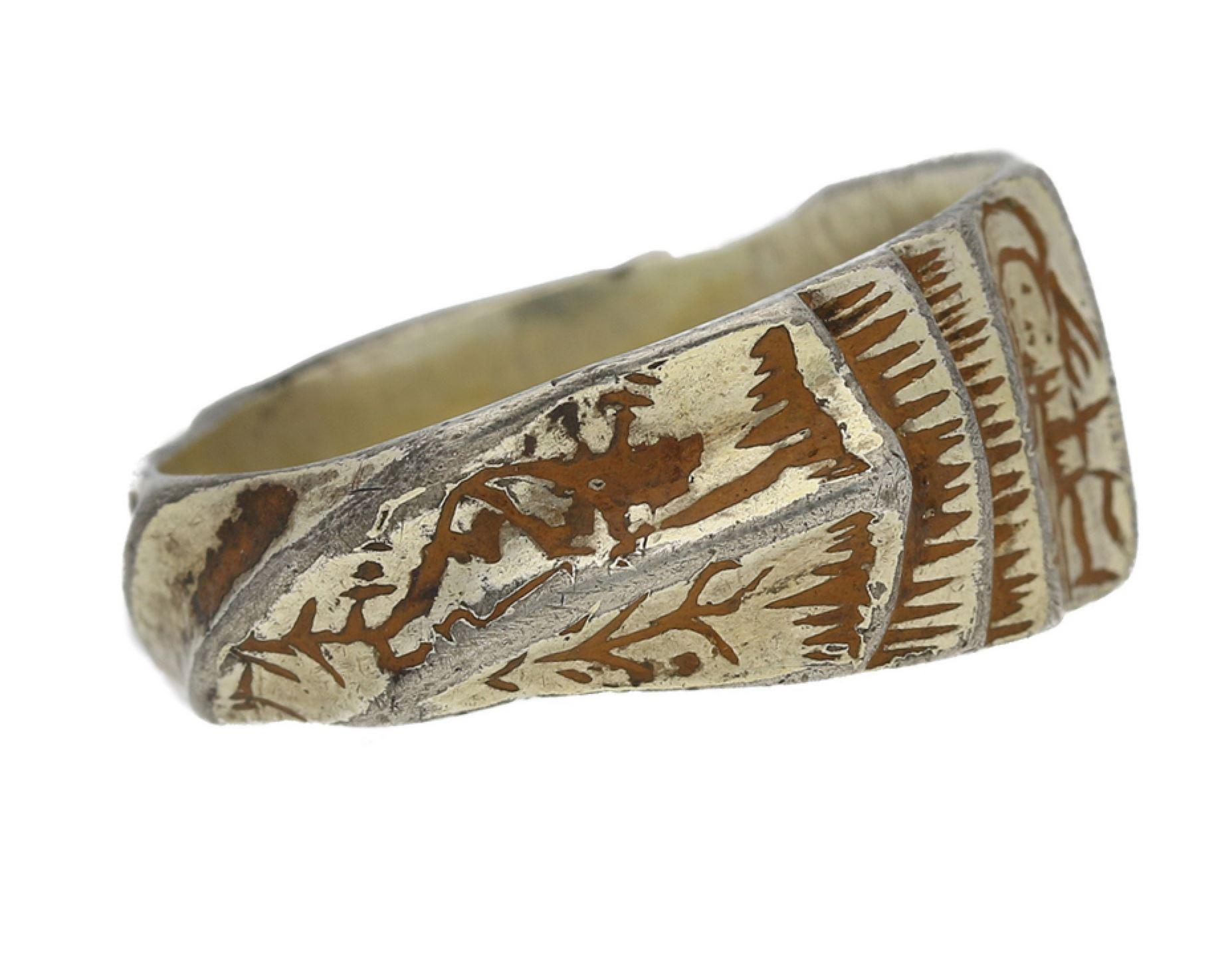 Medieval gilt iconographic saints ring. The central plaque with grooved panels, engraved vertically with two standing saints, flanked by shoulders with raised twisting channels, engraved between with stylised foliate motifs and chevron detail,