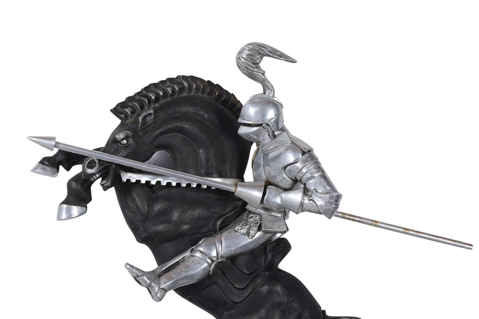 This vintage medieval lance knight wall sculpture is made out of aluminum and is in good condition. This piece features a knight and his horse in a full charging position. The horse is black painted aluminum with polished hooves and eyes, the knight