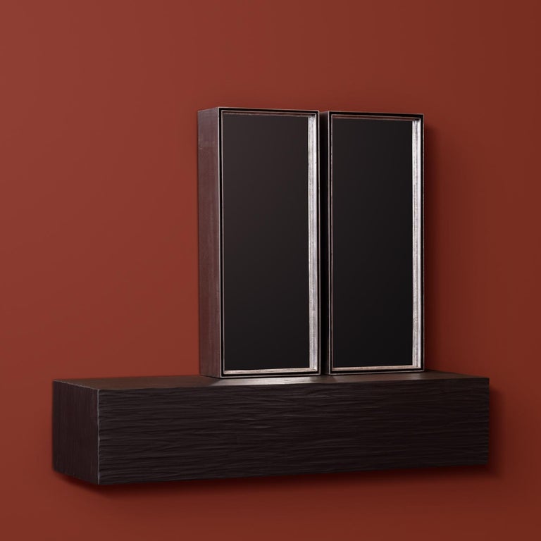 'Talisman mirror No. 5' by Rooms Studio is an iron-framed double mirror mounted on a carved and blackened wall-hung oak shelf. This work is part of a limited edition series entitled Talisman Mirrors, whose forms unapologetically borrow from