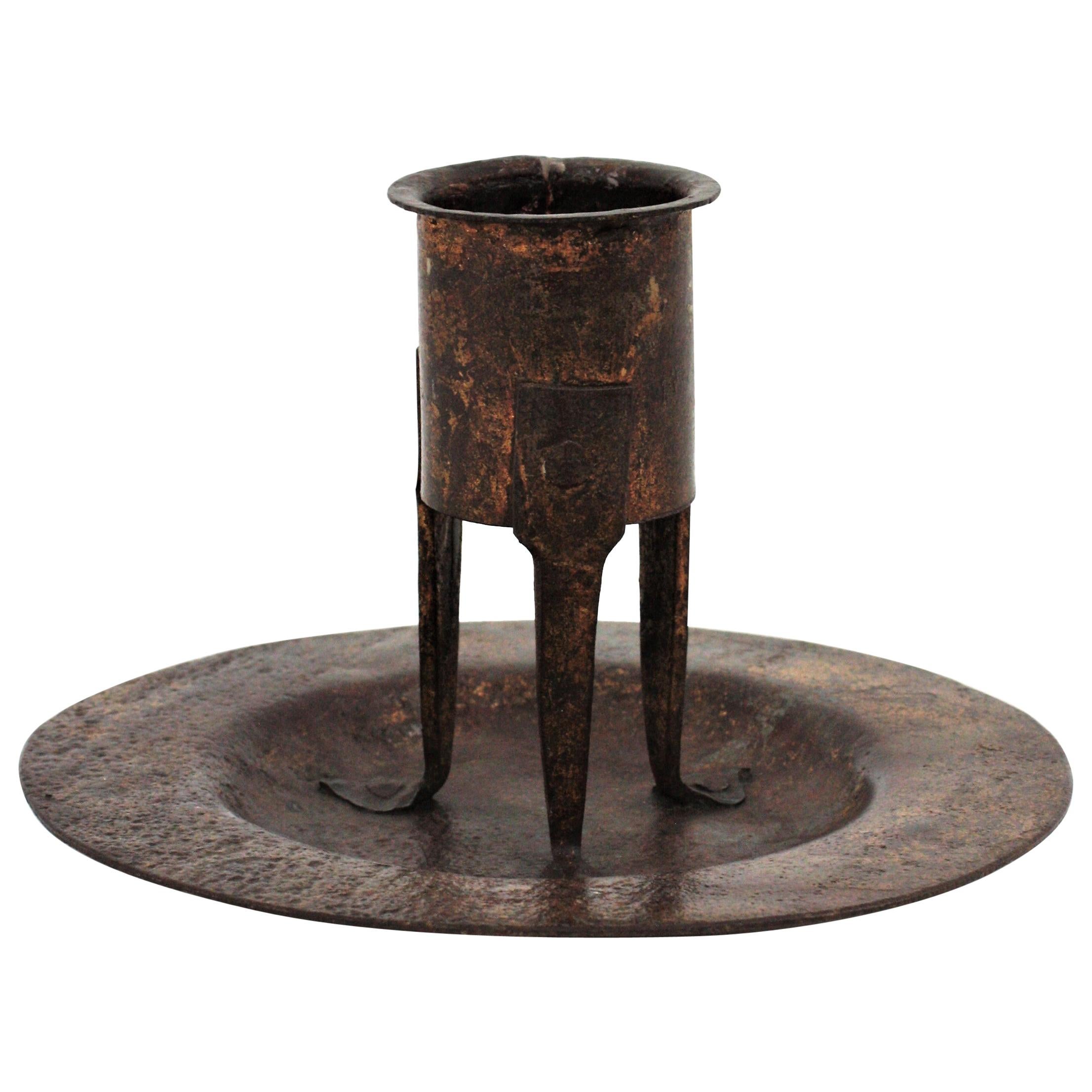 Gorgeous handwrought iron round plate with standing candleholder, Spain, 16th-17th century.
This medieval style candleholder stands up on three legs on a round plate. It has a terrific aged patina retaining rests of its antique gold leaf
