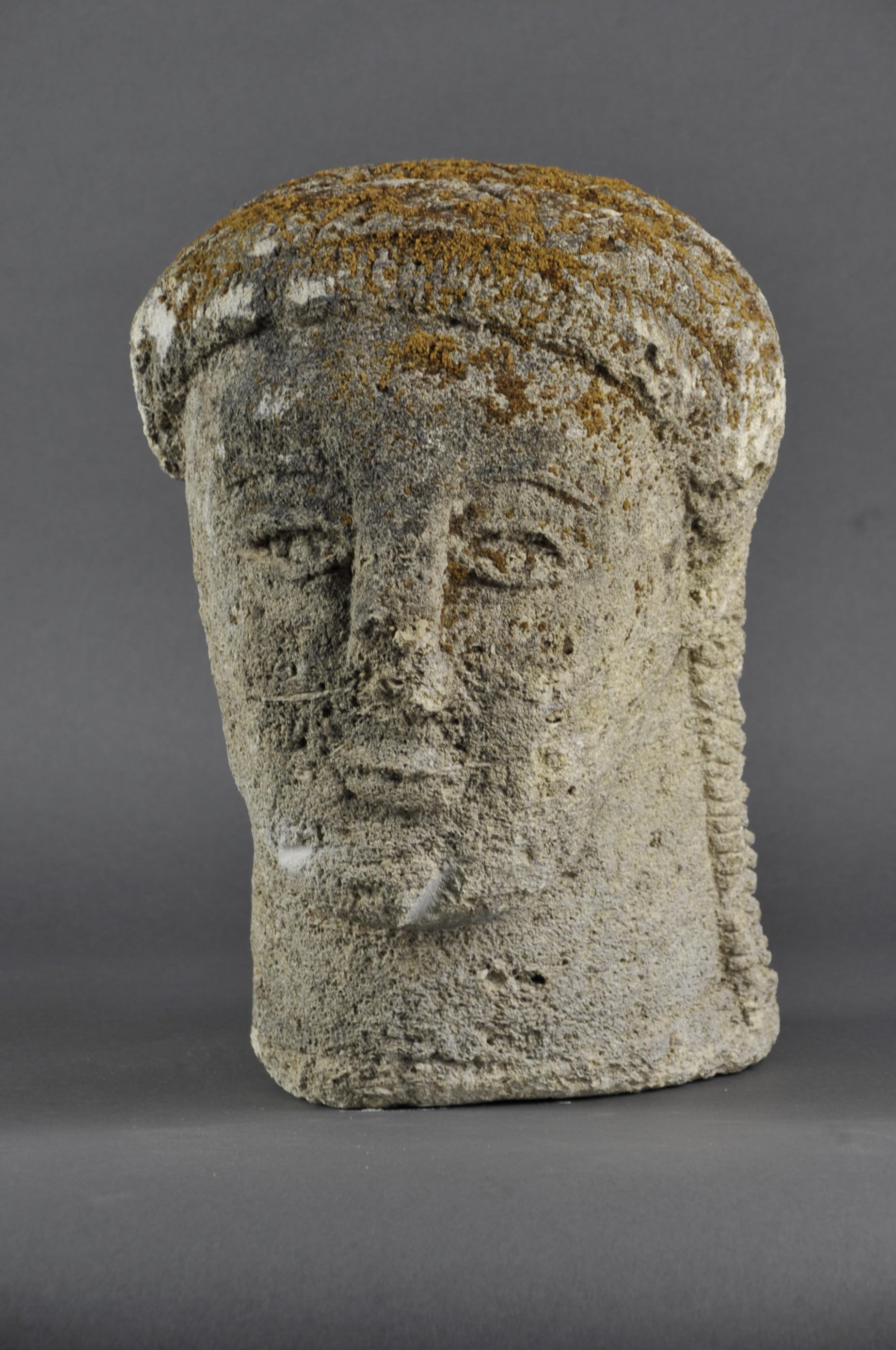 Soft limestone sculpture depicting a woman's head wearing a gorget-type headdress.

Religious work, possibly from medieval times. The fact that it is in soft stone implies an indoor location (in a church) otherwise it would not have withstood bad