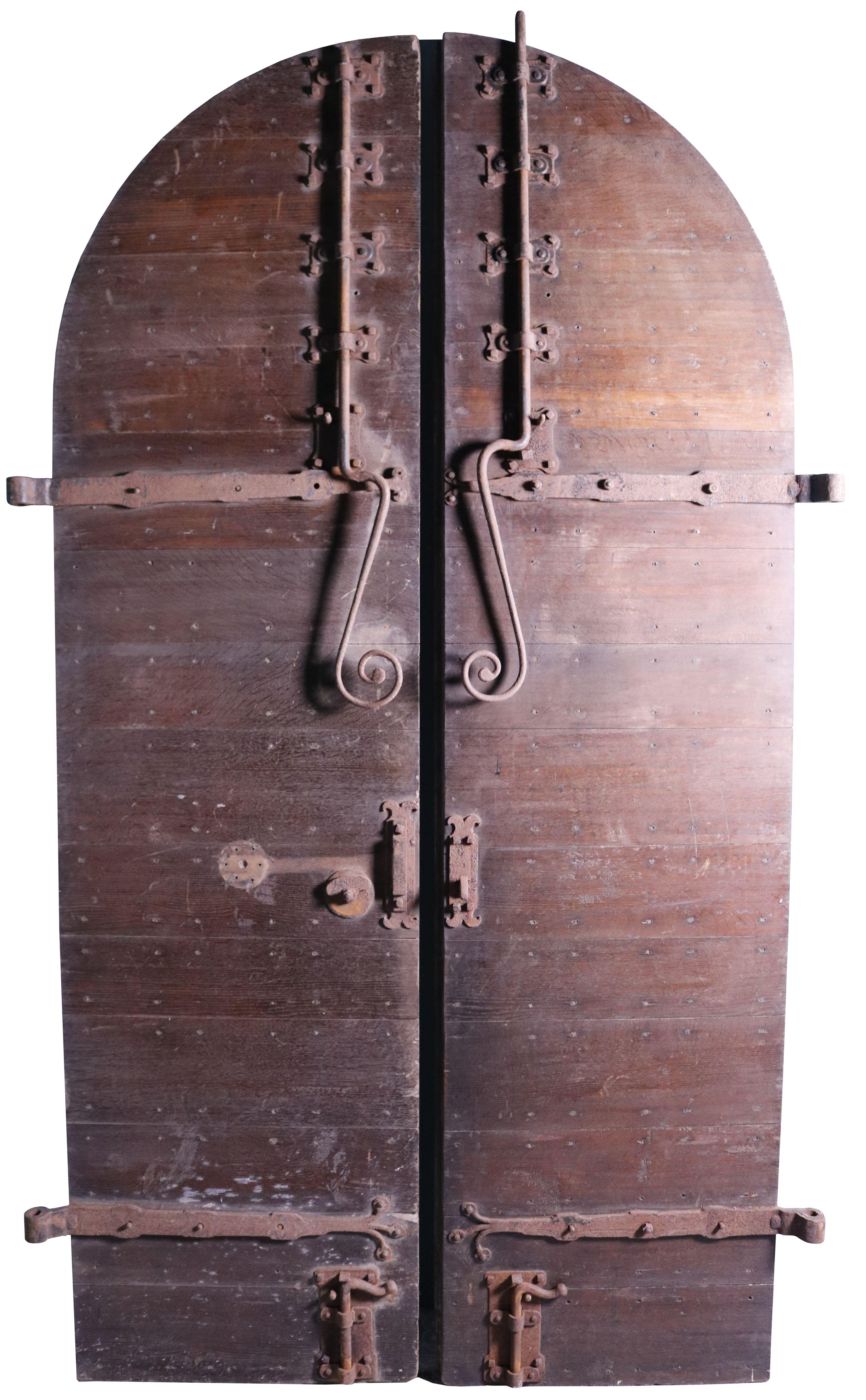 English Medieval Style Church doors. A set of large arched antique doors with original hardware and a weathered time worn appearance. These wonderful studded oak doors feature fantastic blacksmith made wrought iron hinges and door bolts. They are of