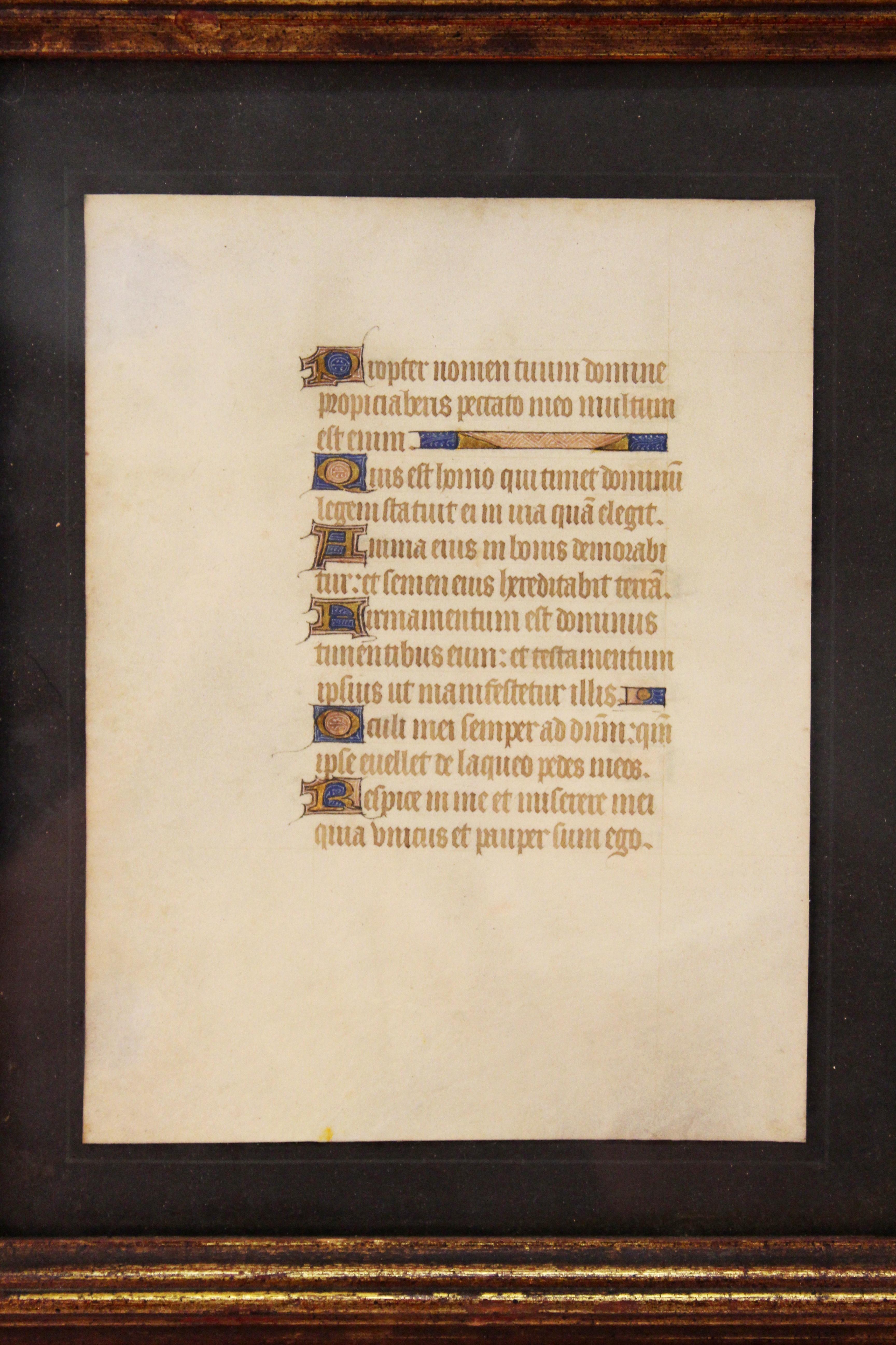 19th century Medieval Style hand-illuminated Latin manuscript page with old enhanced initial letters. The piece is framed and is in good vintage condition.