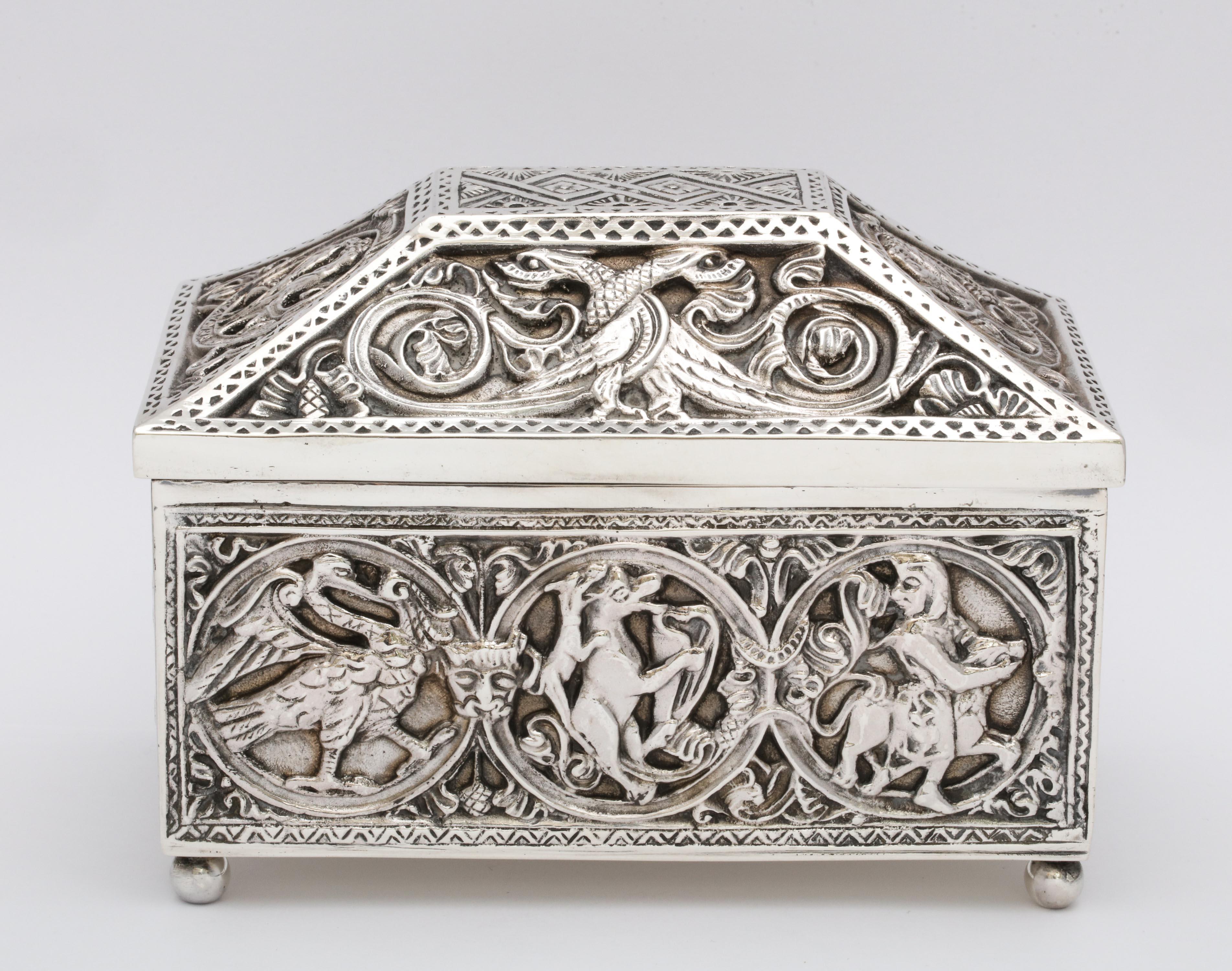 Medieval-style, sterling silver (.950) casket - form jewelry box with hinged lid, having bun feet, Paris, circa 1900. Suede lined. Designed with mythical birds and scenes. Measures 4 3/4 inches high (at highest point) x 6 inches wide x 3 3/4 inches