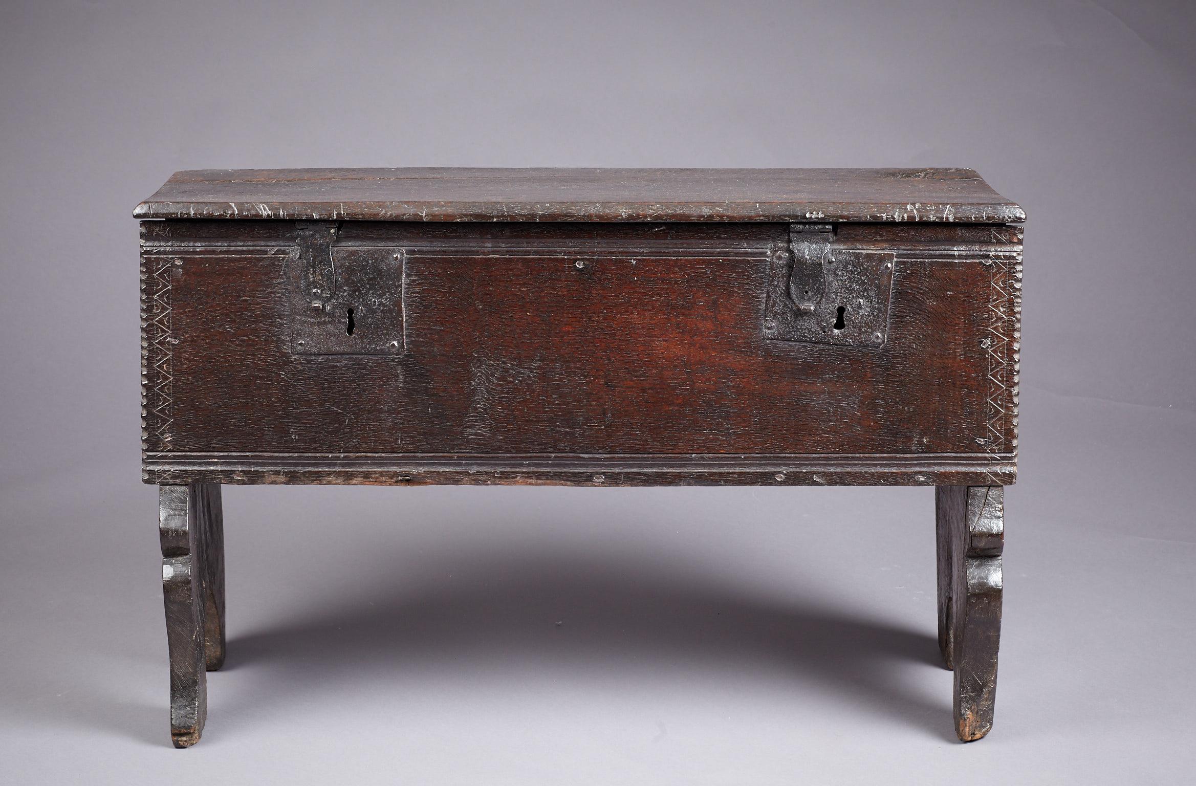 Medieval - Tudor oak boarded / plank chest, Henry VII / Henry VIII period, English, circa 1480-1530.

The plank lid with chamfered edges above a twin moulded, chip carved and chevron incised front panel with original twin locks, joined by bold arch