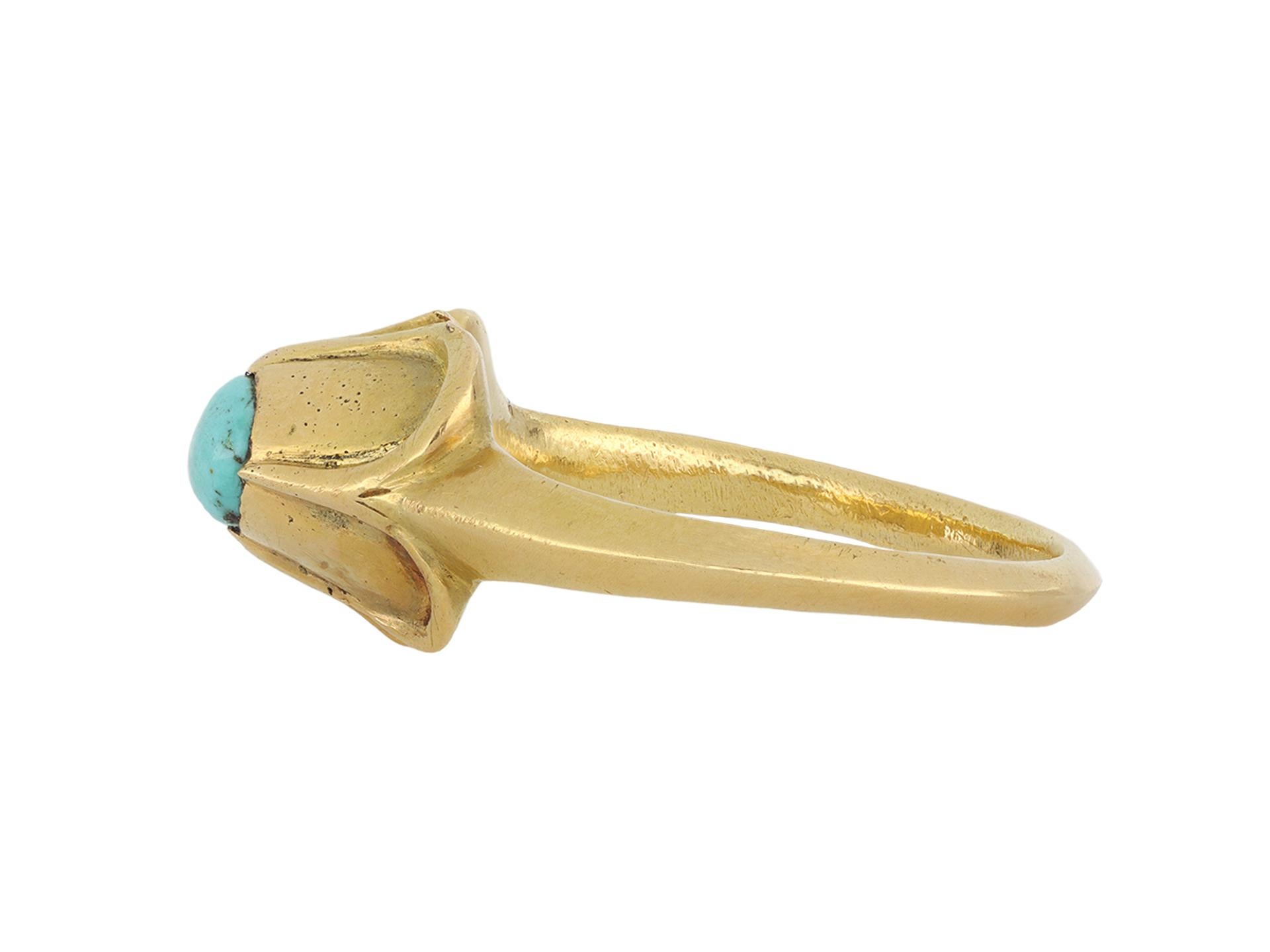 Medieval turquoise stirrup ring. Set with an oval cabochon natural turquoise in a closed back rubover and claw setting, to an impressive stirrup design featuring a raised bezel with a quatrefoil design, a carved gallery and closed backholing,