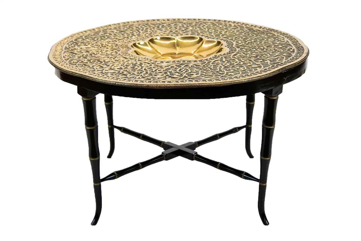 Mediterranean brass tray table is cast with profuse arabesques stamped in high relief. The center has a recessed octagonal stylized flower. The base was custom made in 1995.