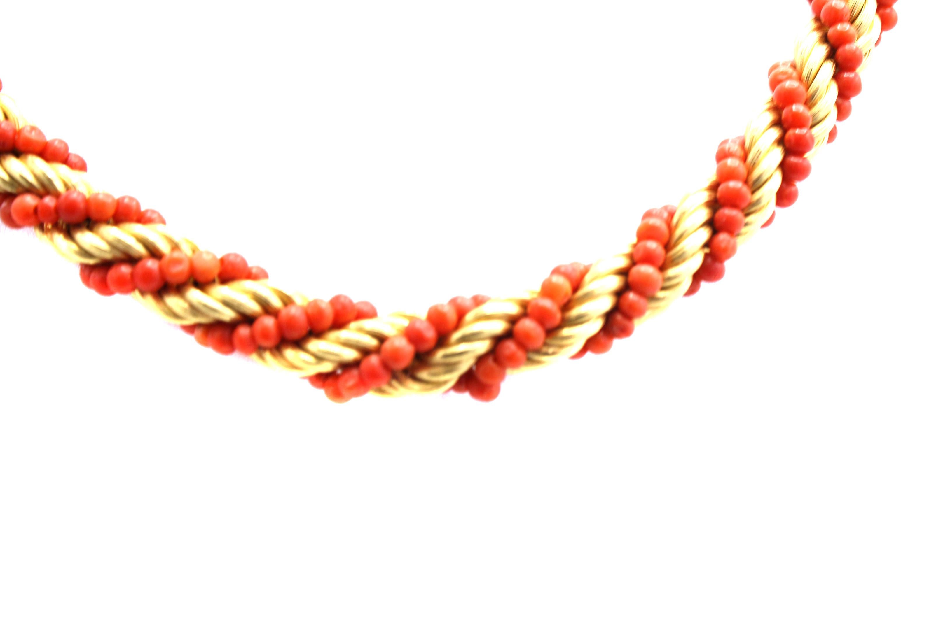 Beautifully designed and wonderfully hand-crafted perfectly matched coral beads are set in between braided gold bands in the shape of a twisted rope. This multi-functional chic piece of period jewelry can be worn as a pair of bracelets, each