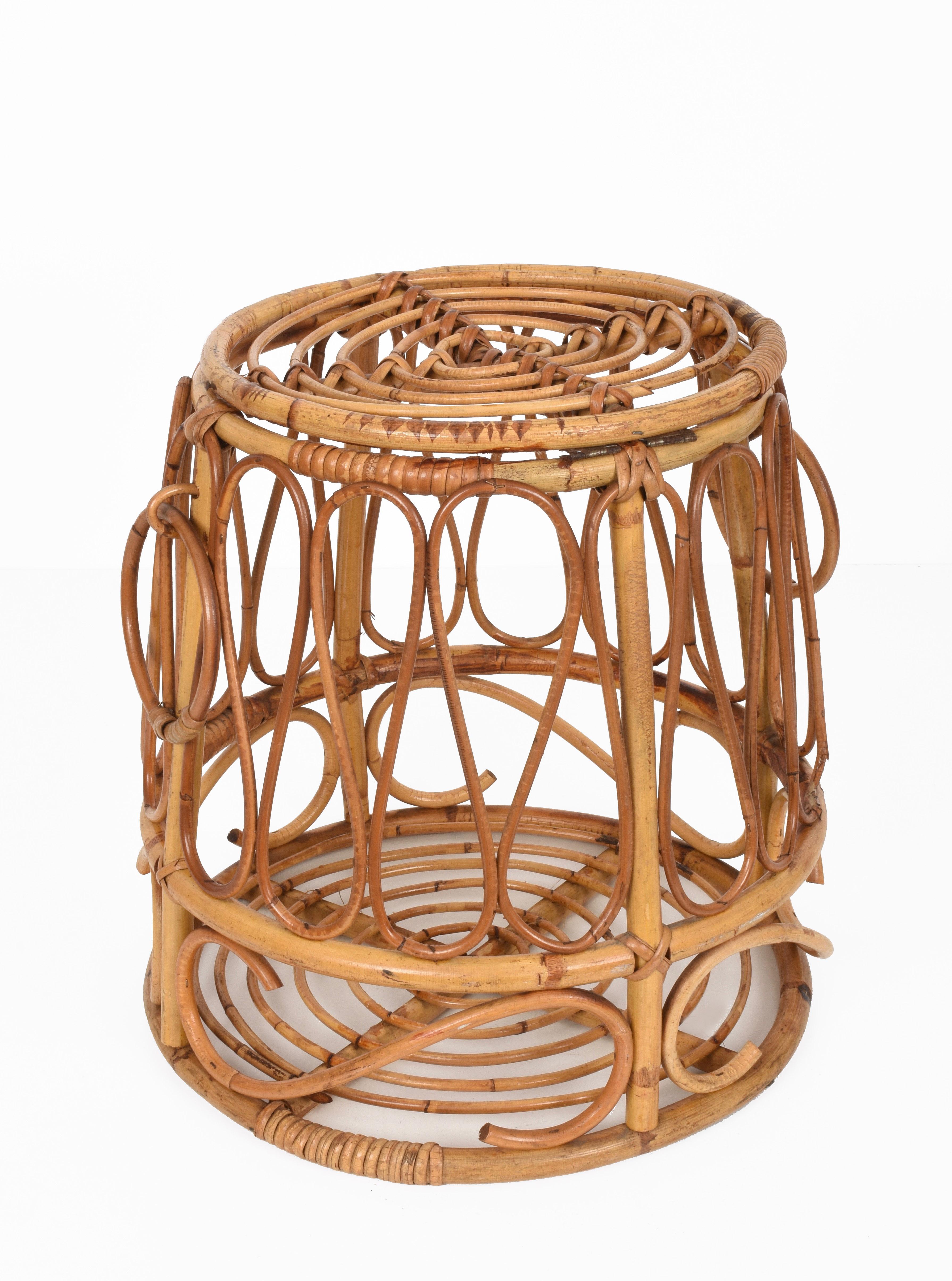 Beautiful midcentury circular storage decorative basket in bamboo and rattan. This amazing item was produced in Italy during the 1950s.

This wonderful piece has a round bamboo frame with rattan trim and two round handles. The top of this basket