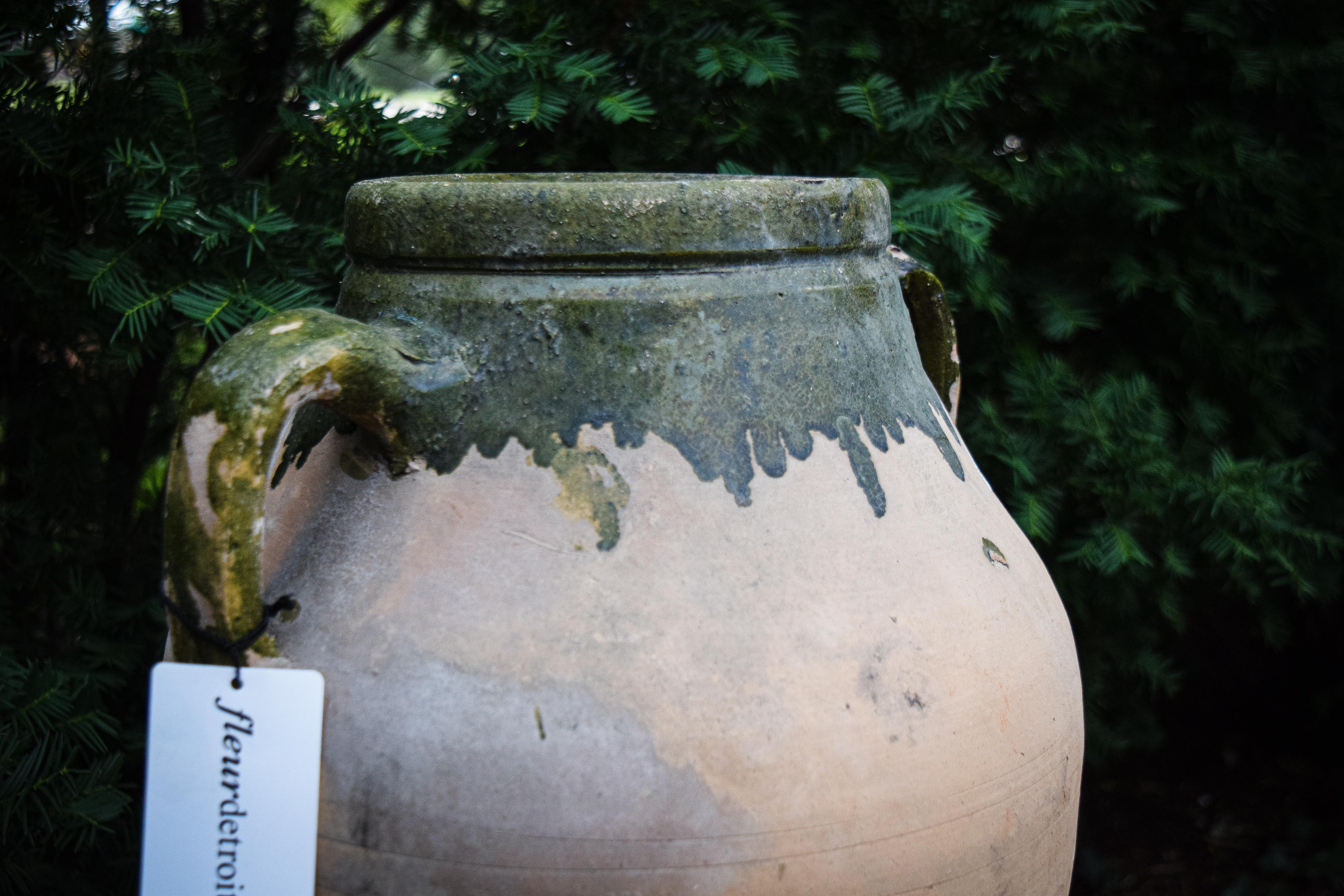 Enhance your space with classic European style featured in this antique olive jar. Featuring remnants of green glaze at the top artfully applied and preserved with perfect weathering. Evoking old world aesthetic, this jar has a distinctive style
