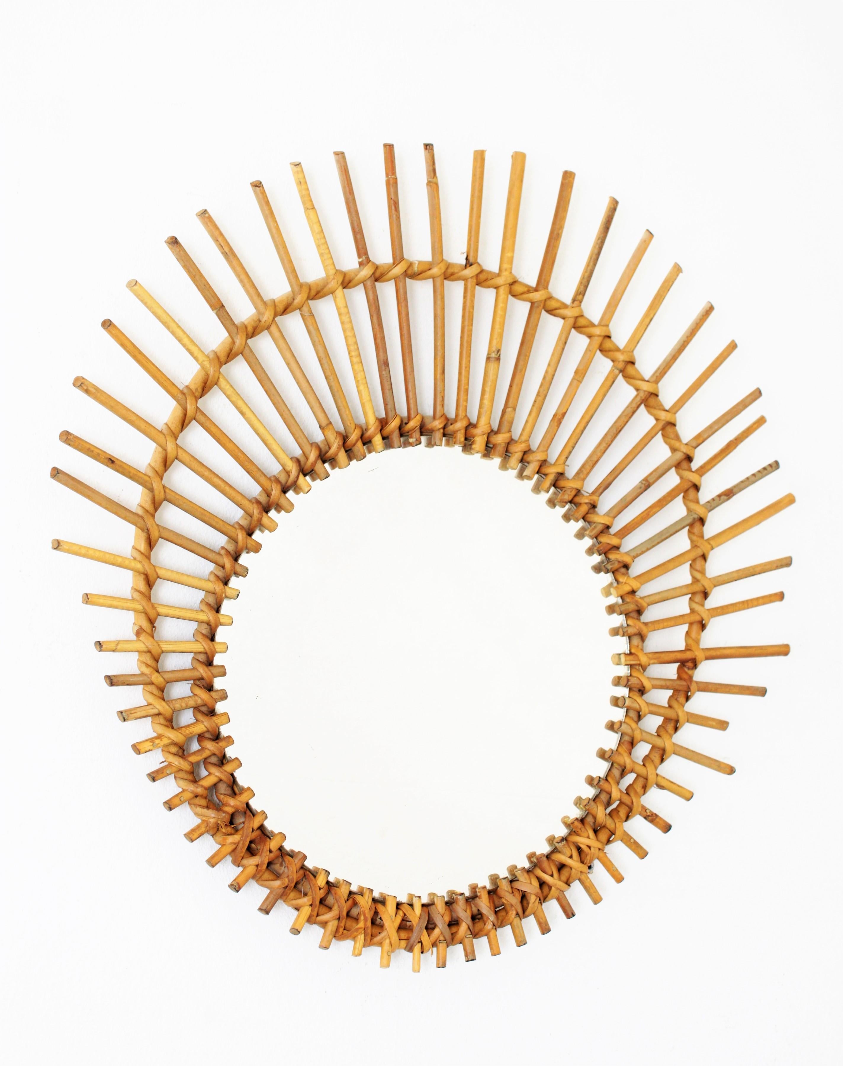 Vintage rattan or wicker ovoid shaped asymmetric sunburst mirror. This piece has all the taste of the Mediterranean coast style and it is in excellent vintage condition, France, 1960s. Glass diameter: 29.5cm.
Beautiful to place in a wall decoration
