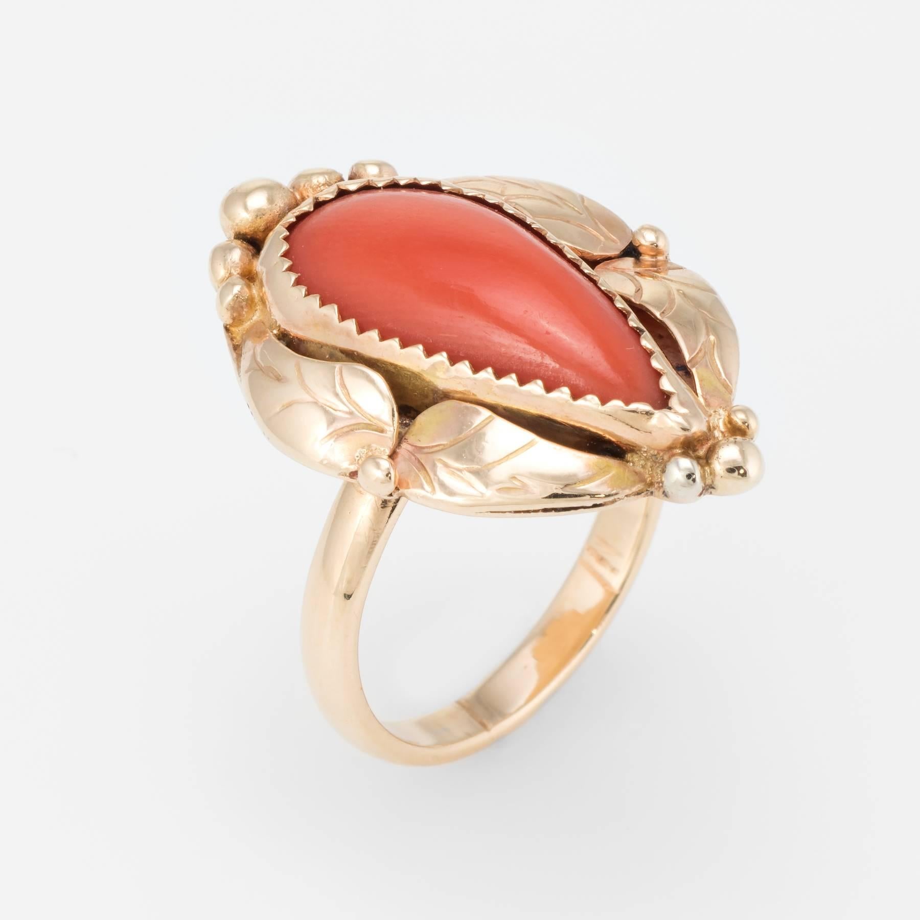 Elegant vintage cocktail ring (circa 1960s), crafted in 14 karat yellow gold. 

Centrally mounted cabochon cut Mediterranean Coral measures 16mm x 7mm (estimated at 3 carats). The coral is in excellent condition and free of cracks or chips.   

The
