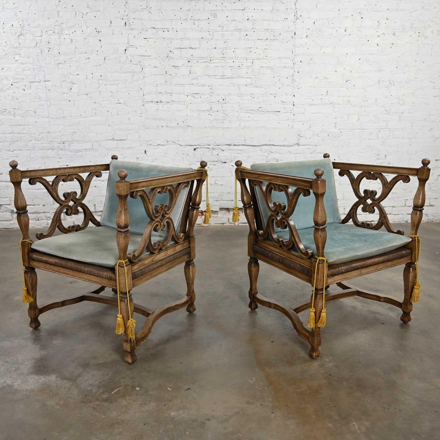 Awesome and unusual pair of Mediterranean or Spanish Revival style chairs with rush seats and loose ice blue velvet cushions attributed to American of Martinsville. Beautiful condition, keeping in mind that these are vintage and not new so will have