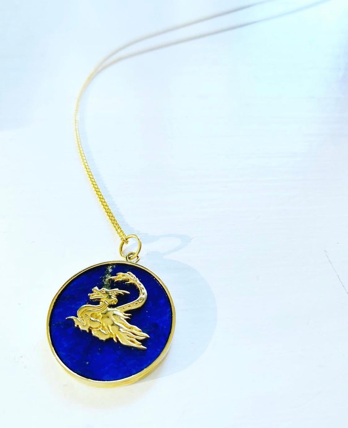 Questo Drago su lapislazzuli è scolpito a mano nella cera e fuso in oro 14kt e rappresenta uno dei dodici segni animali dello Zodiaco cinese. Ogni pezzo misura circa 25 mm ed è leggermente più grande di un nichelino.  La catena non è inclusa.