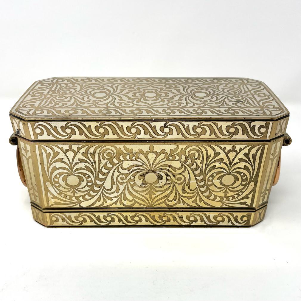 Medium Betel Nut Box, Maranao, Southern Philippines (Mindanao).
Bronze/Brass with bordered silver inlay design overall of a symmetrical floral tendril vine pattern referred to as “the okir pattern”,  a traditional design for the Maranao people. This