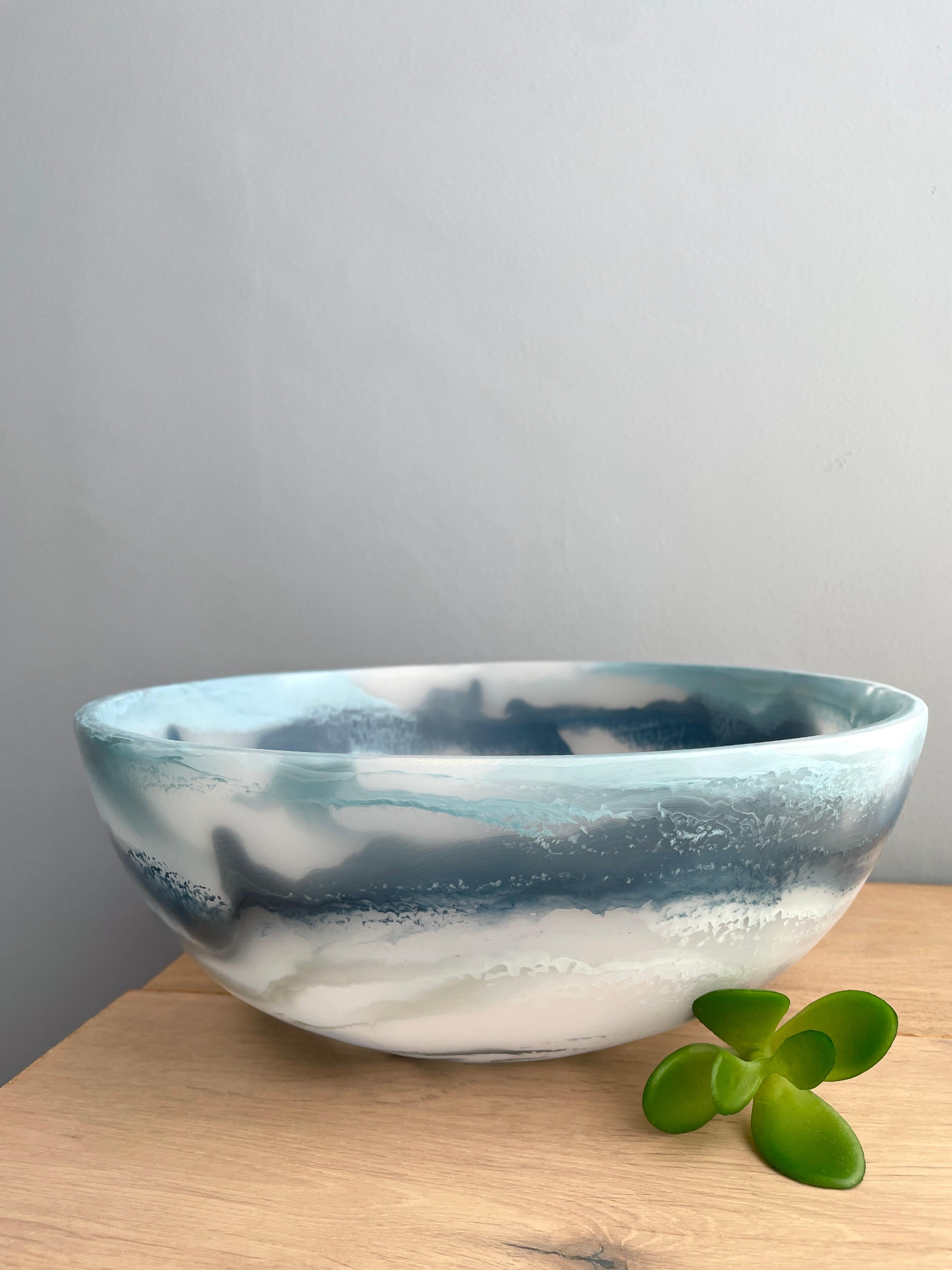 La nostra ciotola colorata è realizzata a mano in resina bianca traslucida con texture marmorizzata in tre tonalità di blu. Il suo design divertente e colorato lo rende un pezzo forte e può essere usato come decorazione, come piatto di frutta o per