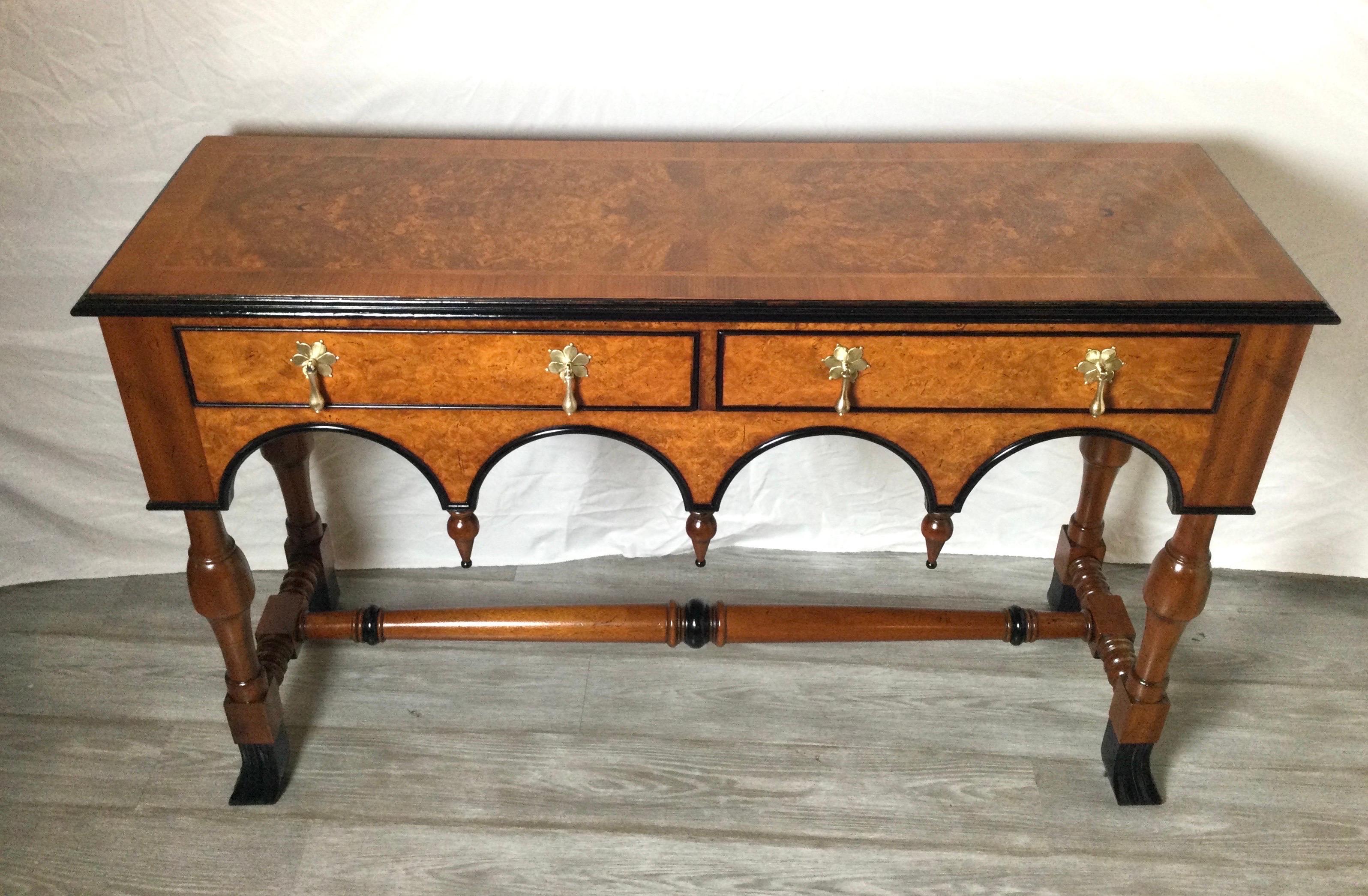 Elegant medium color burl walnut William and Mary style console table. The book matched walnut top with ebonized trim all around. The table with two drawers and beautifully scalloped apron. Original burnished brass drop hardware. European made,