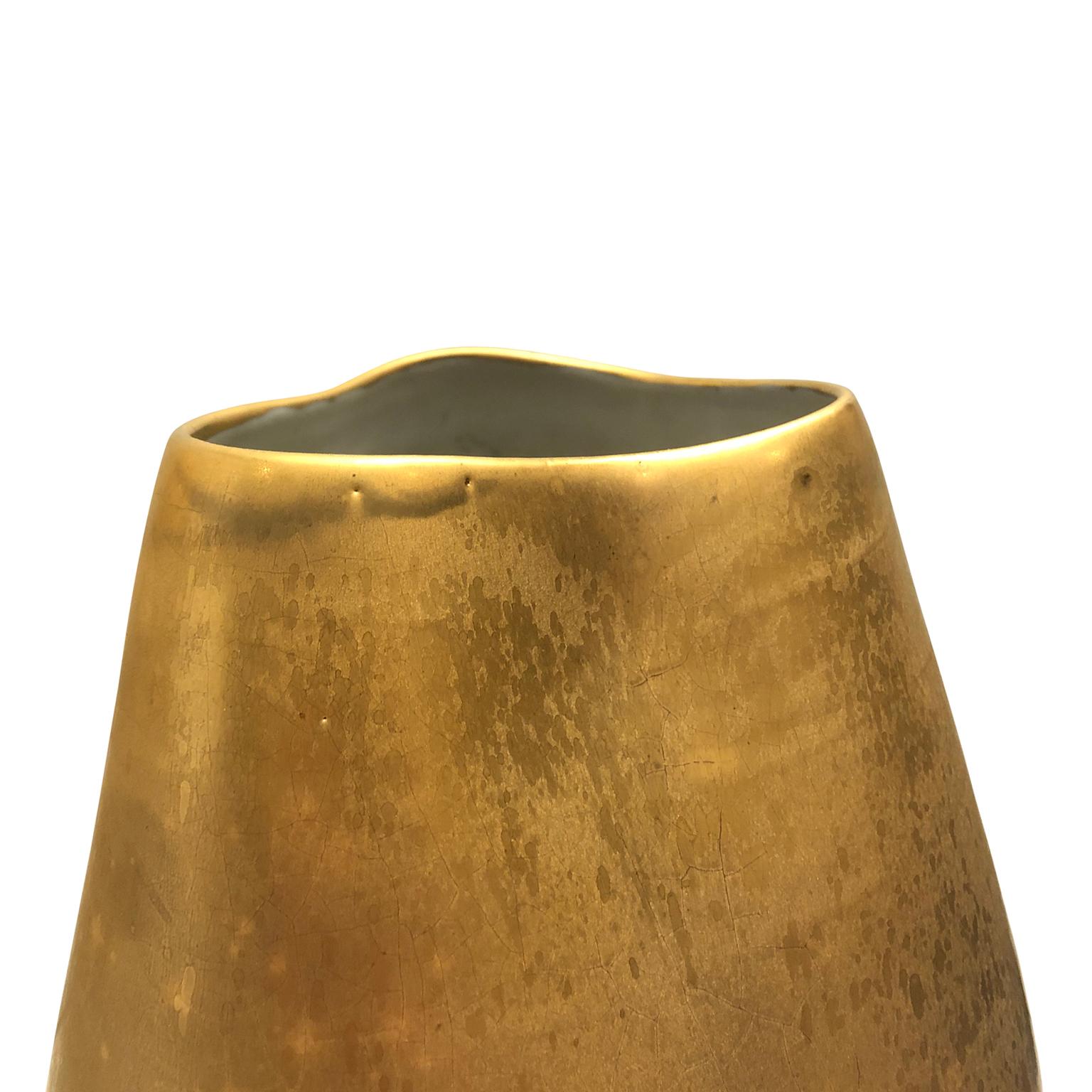 Medium ceramic vase with dent and burnished gold lustre glaze by Sandi Fellman, 2019. 

Veteran photographer Sandi Fellman's ceramic vessels are an exploration of a new medium. The forms, palettes, and sensuality of her photos can be found within