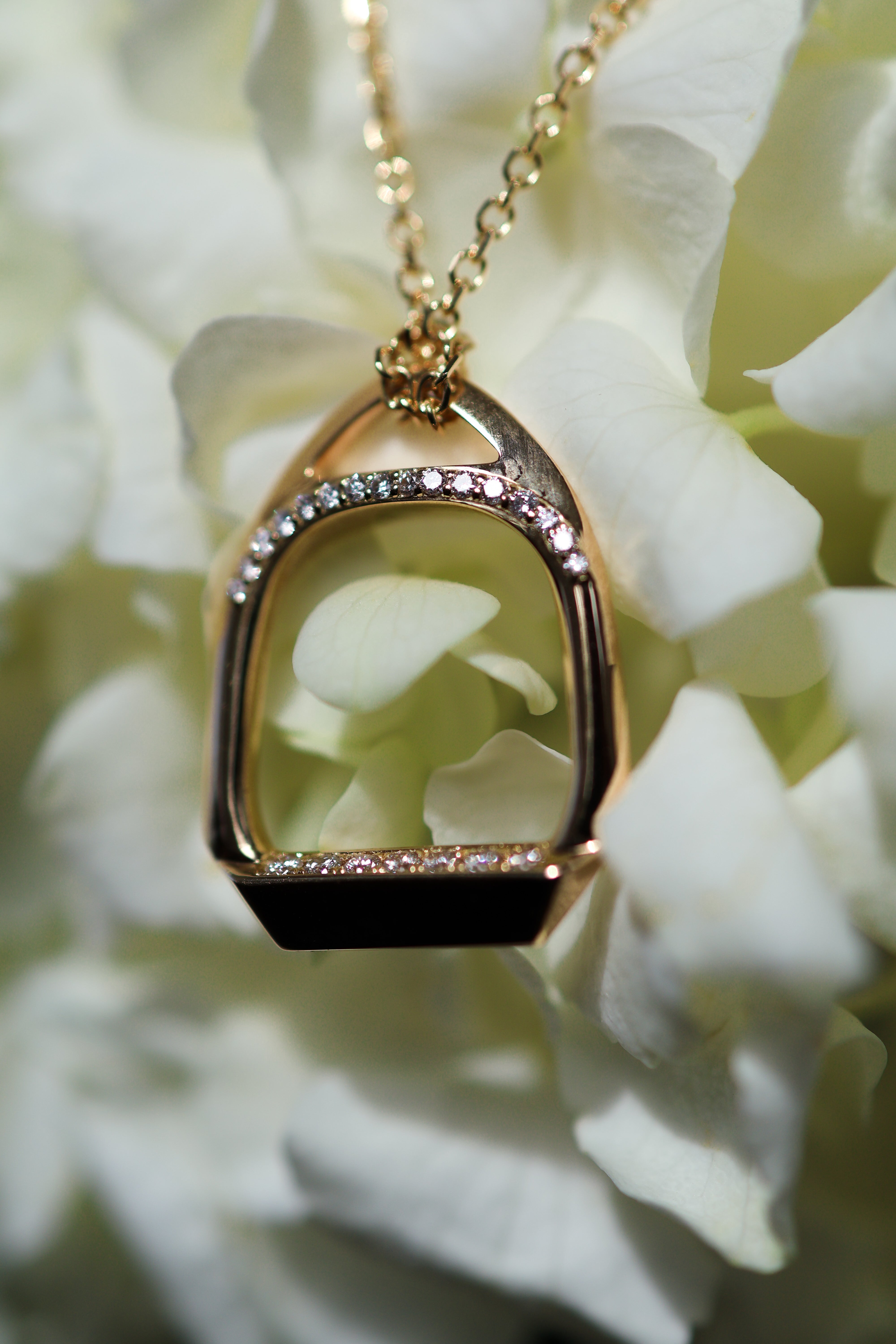 Dieses exquisite Steigbügelcollier besticht durch eine Brücke aus nach vorne gerichteten Diamanten, die durch eine Reihe von Diamanten entlang des Fußpads makellos akzentuiert wird. Die Kette aus 18 Karat Gelbgold verleiht diesem bezaubernden