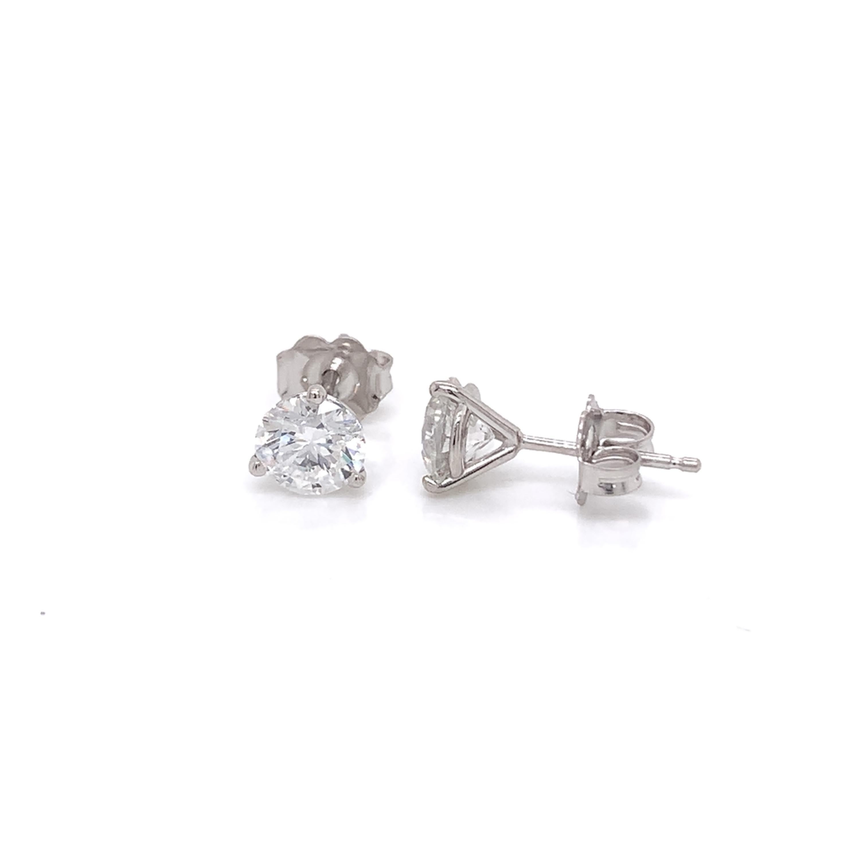 Diamond Stud Earrings made with real/natural brilliant cut diamonds. Total Diamond Weight: 1.43 carats. Diamond Quantity: 2 (round diamonds). Color: F-G Clarity: SI2-SI3. Set on a 3 prong mounting in 18 karat white gold, push-back setting.
