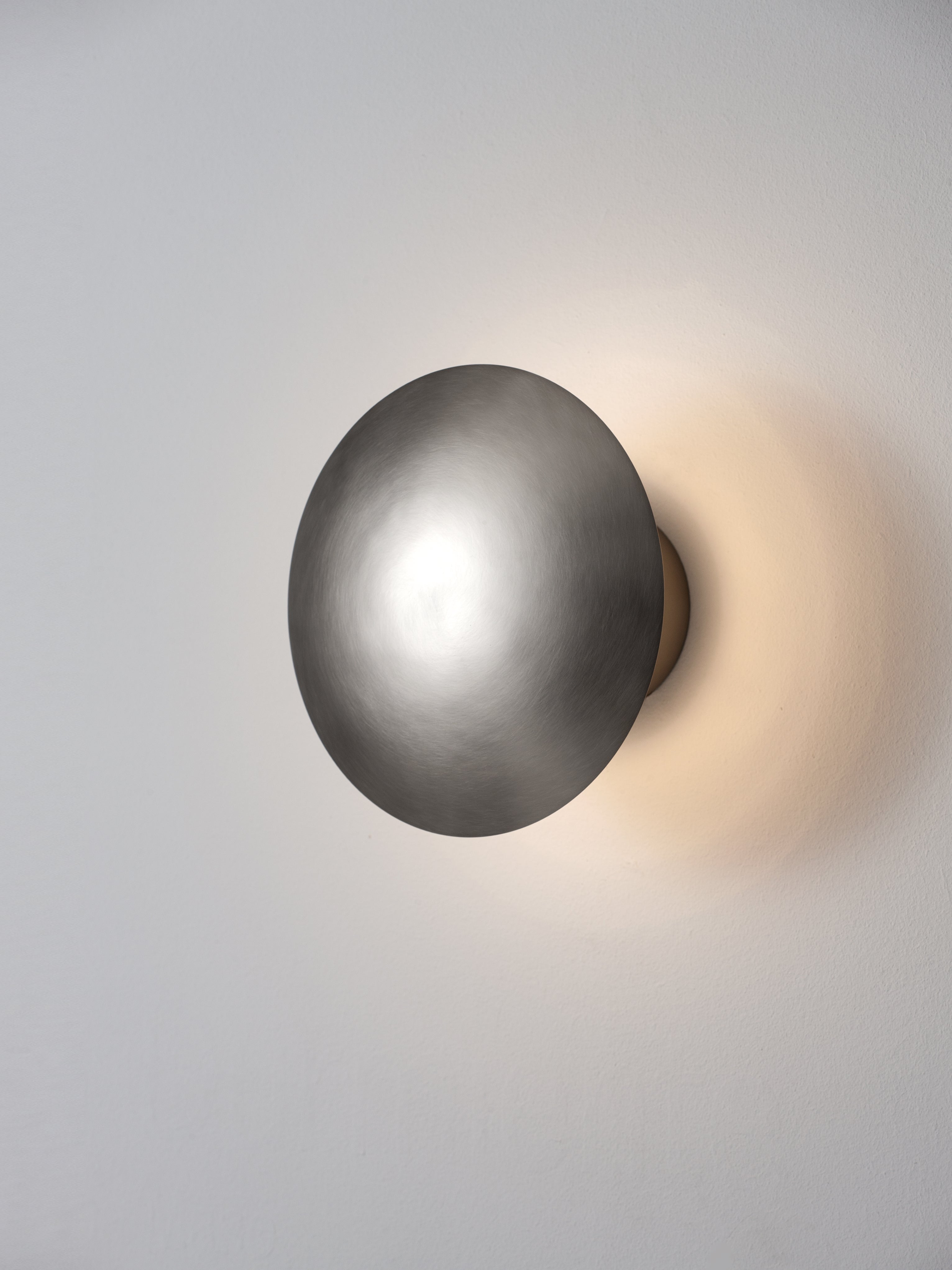 Medium Disco wall lamp by Jordi Miralbell, Mariona Raventós
Dimensions: D 24 x W 13 x H 24 cm
Materials: Metal.
Available in 2 sizes: D24, D35 cm.

This metallic disc, available in two sizes, M and L, reflects its light on the wall, creating a