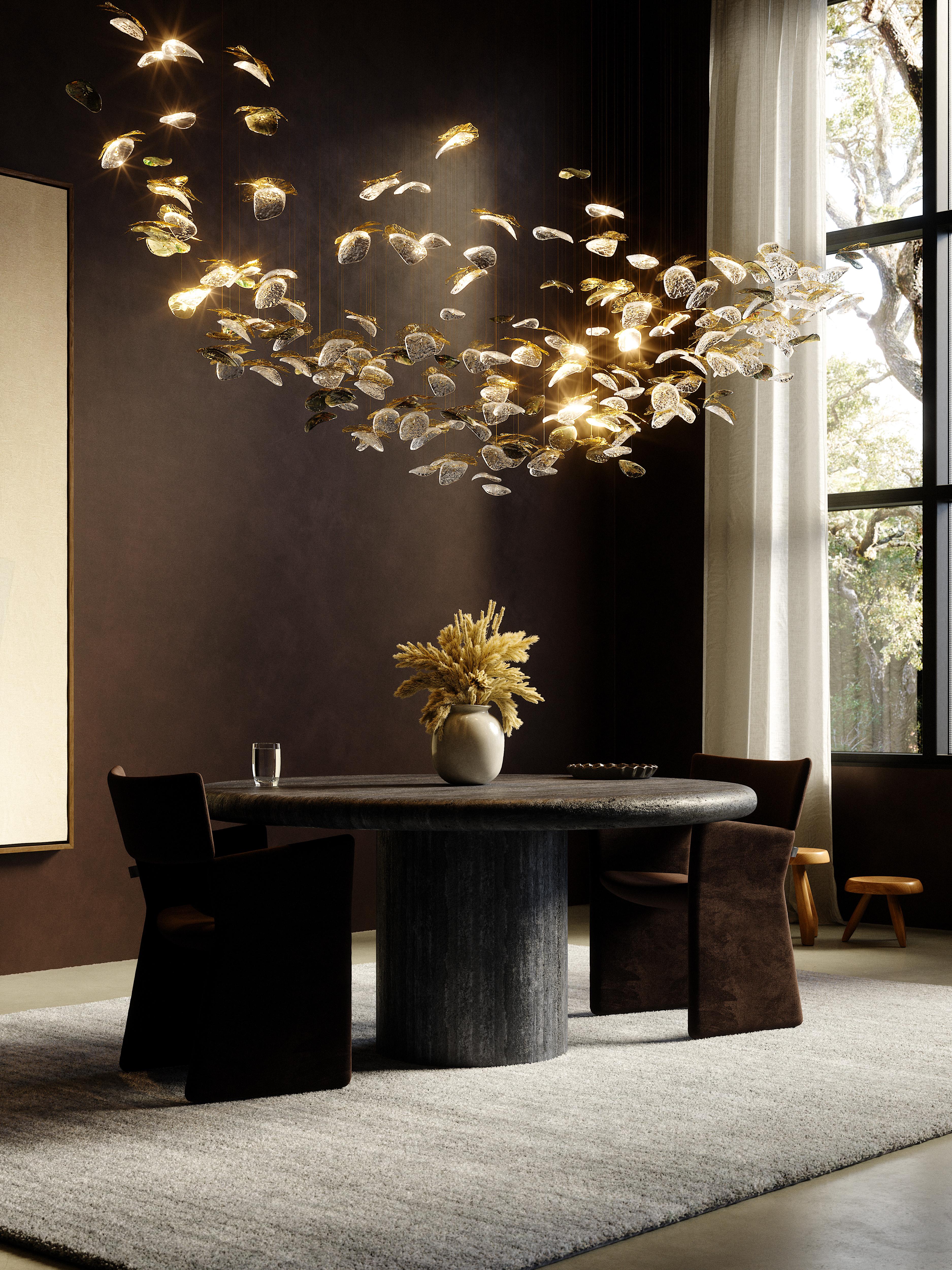 Lampada a sospensione a cupola media di Rock and Soar
Dimensioni: W 200 D 150 x H 85 cm
Materiali: Placcato oro, SS.

80 x vetro trasparente, 40 x vetro metallico fumé, 40 incisioni botaniche, 5 accendini

Circa:
Fondata dalle creative Monica