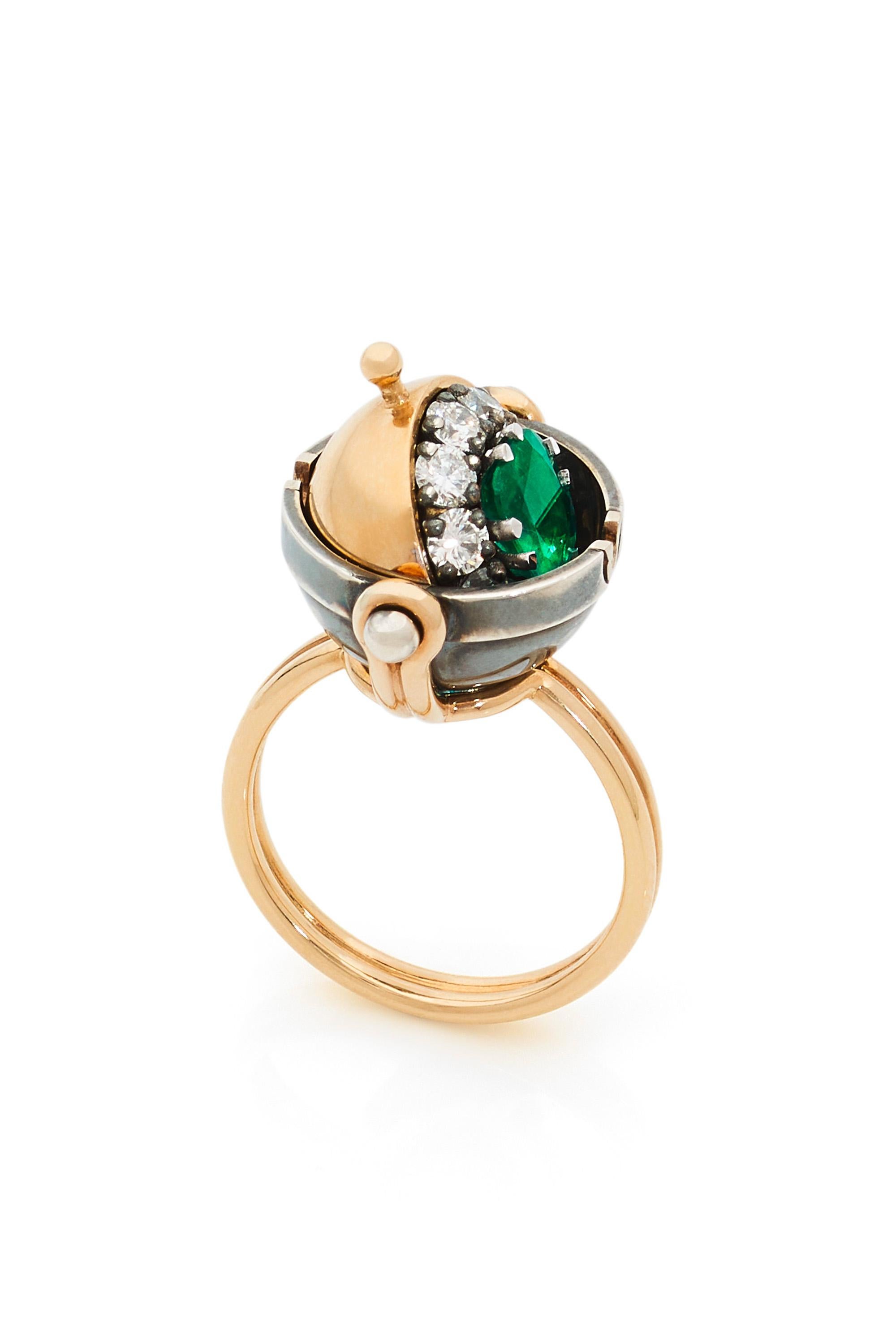 Gold and distressed silver ring. Rotating sphere set with a star diamond and revealing a cushion-cut emerald surrounded by diamonds.

Details:
Emerald: 0.8 cts
10 Diamonds: 0.65 cts
18k Gold: 6.6 g 
Distressed Silver: 5 g 
Made in France