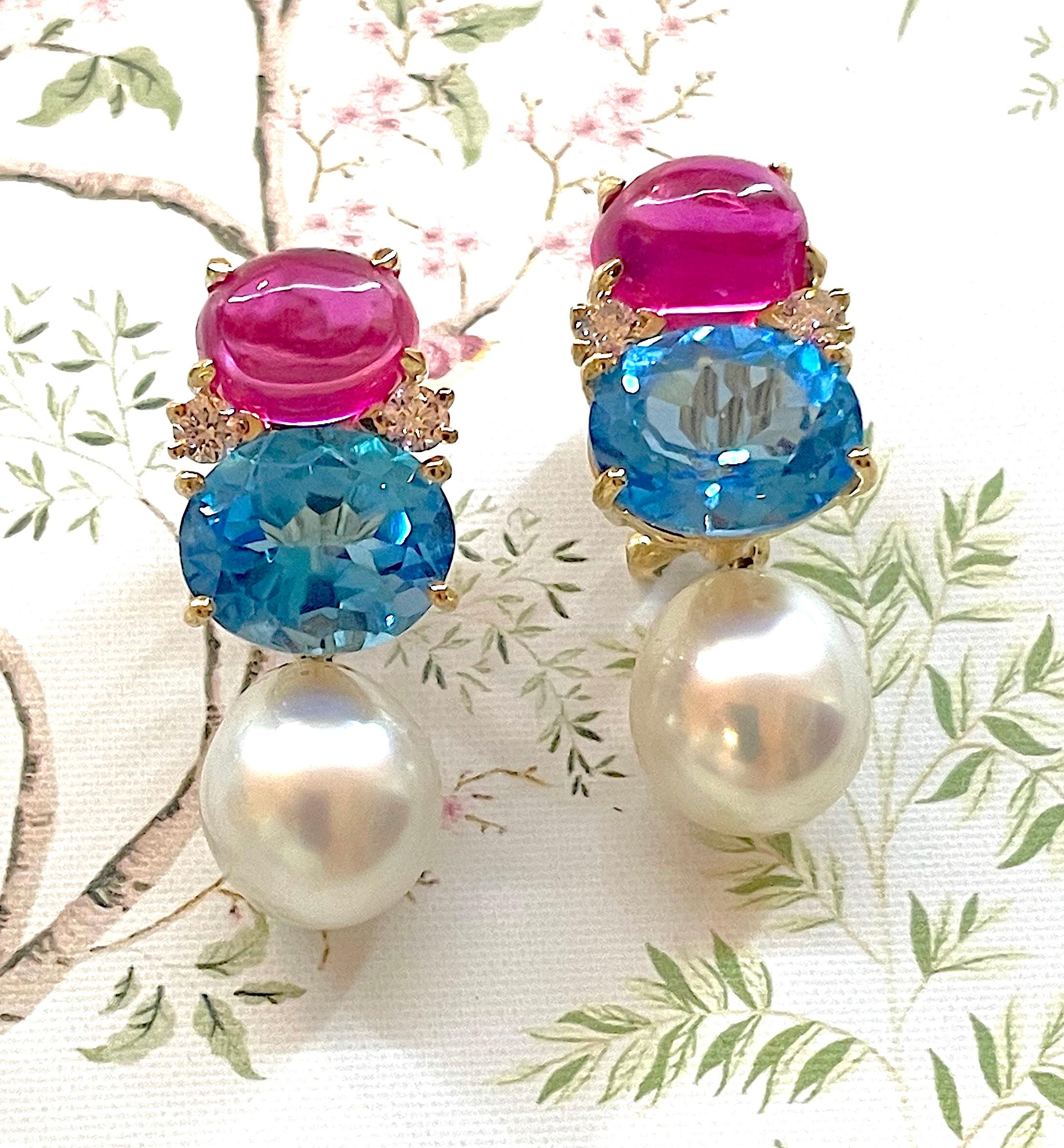 Medium 18kt yellow gold GUM DROP™ earrings with cabochon hot pink topaz and faceted Blue Topaz and four diamonds with detachable pearls is an elegant statement. 

The Cabochon Hot Pink Topaz (approximately 3 cts each), faceted Dark Blue Topaz