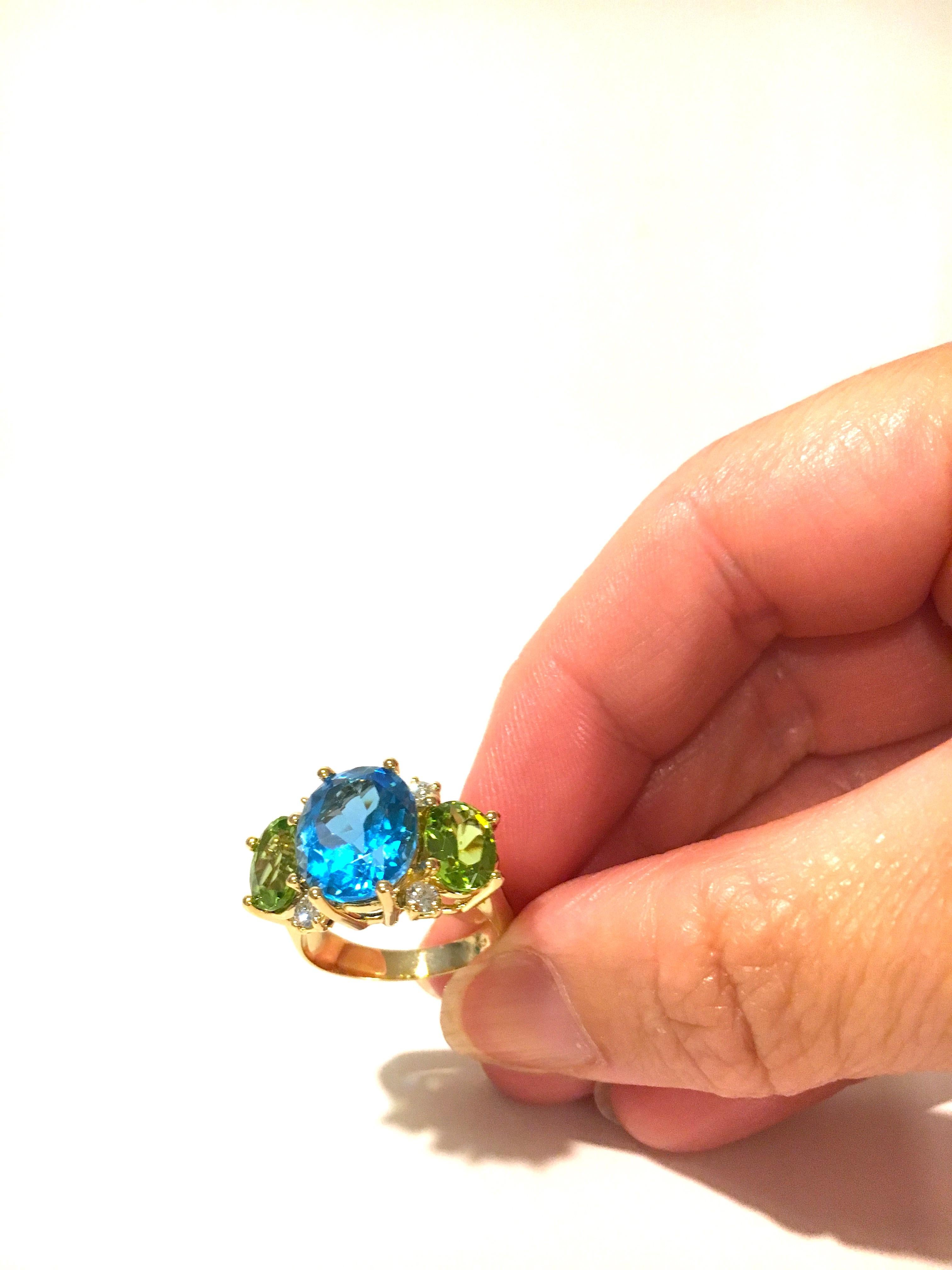 18kt Yellow Gold Medium GUM DROP™ Ring with faceted oval shaped center Blue opaz and two oval faceted Peridot and four round Diamonds ~0.50cts

The Ring measures ~ 1