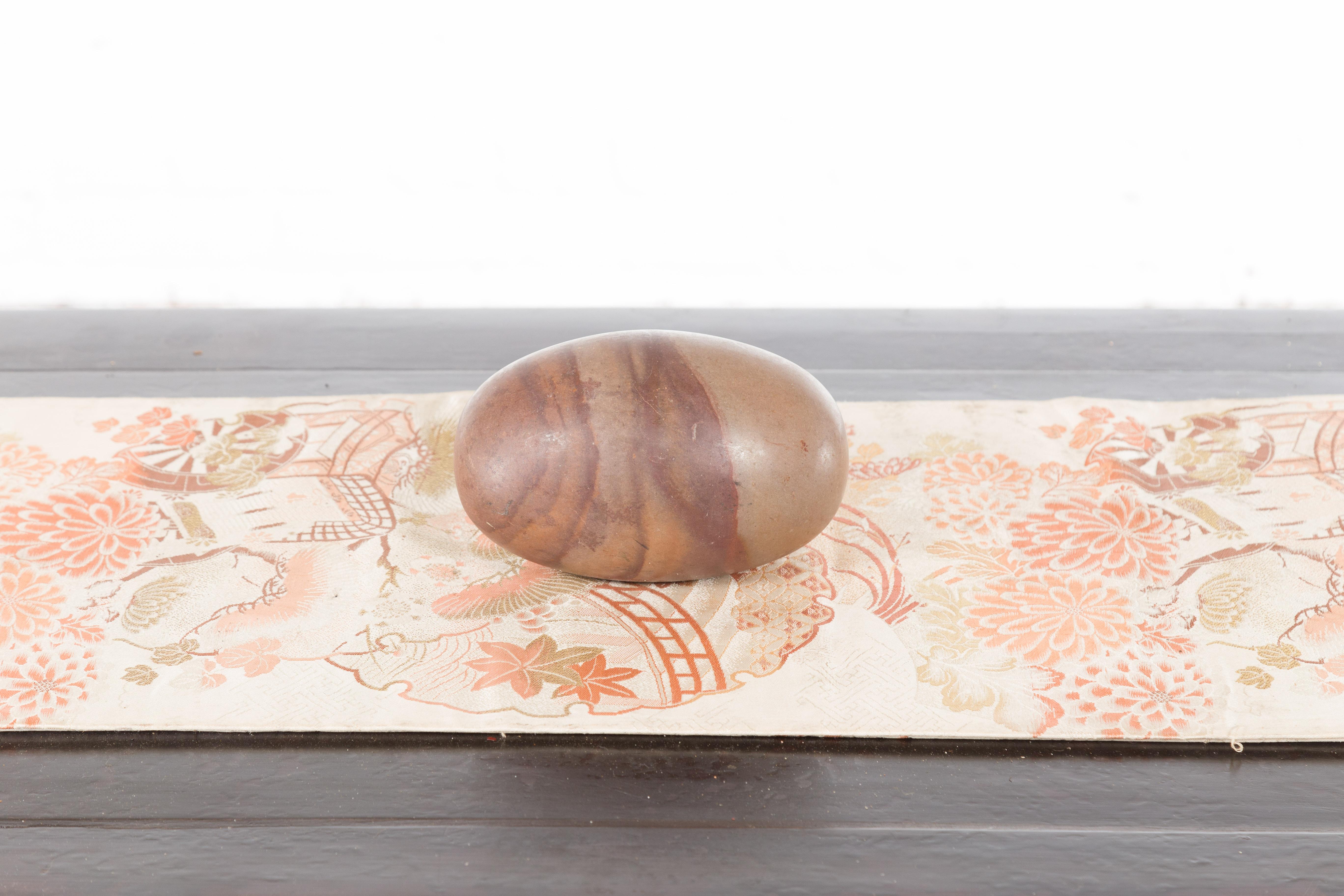 A medium size multicolored stone Shiva Lingam from the Narmada River. We have 10 or more available, each slightly unique and sold loose as pictured. A perfect addition to any home or garden décor, this Shiva Lingam captures the attention with its