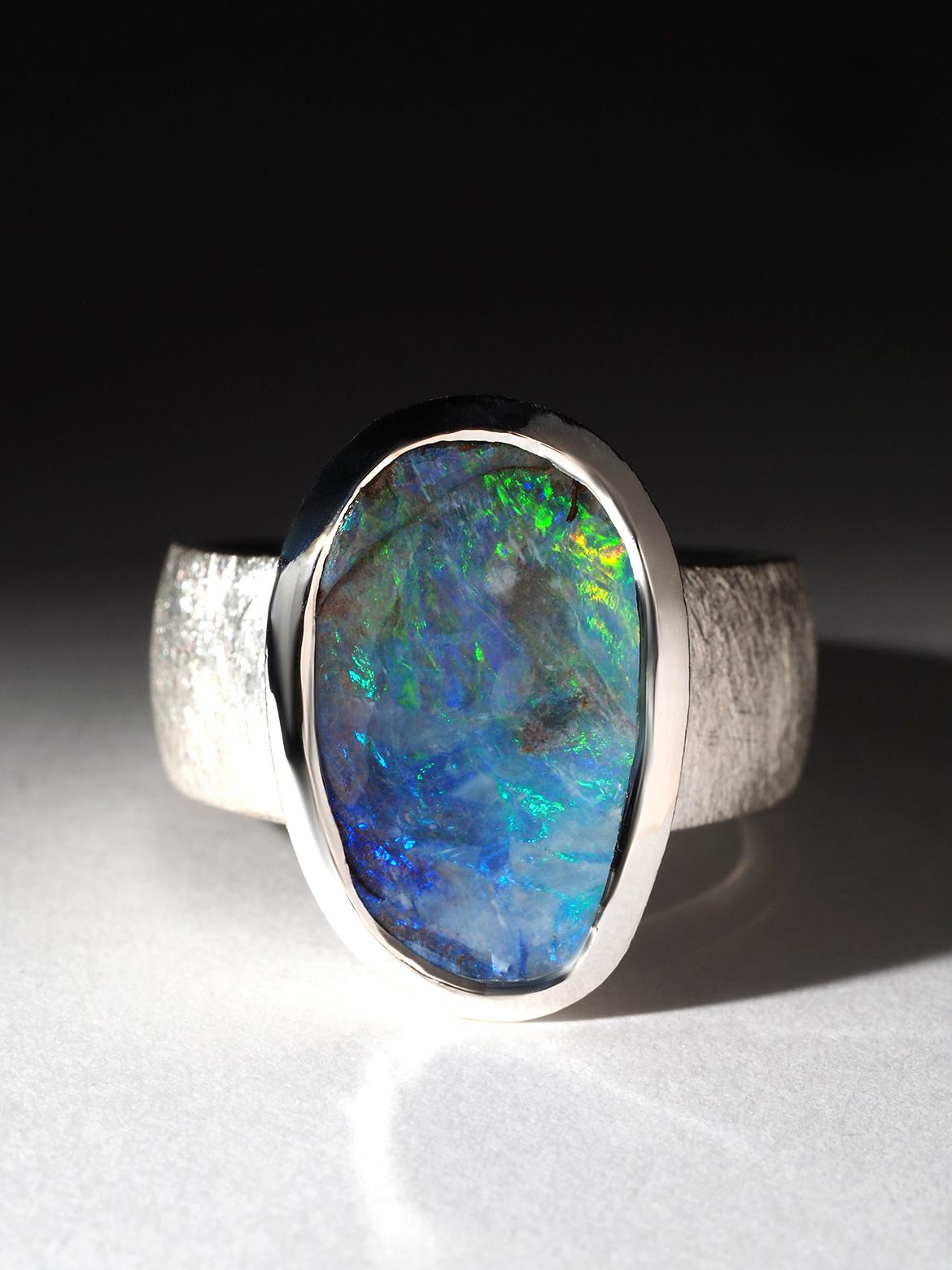 Medium large Australian Opal ring in silver
weight of the ring - 11.5 gr
width of band increasing from 7 to 9 mm
size of the stone - 11 x 18 mm
size of the ring - 58.5, N 19, 8.5 US, diameter 18.5 
weight of the opal - 9.55 ct

Worldwide shipping