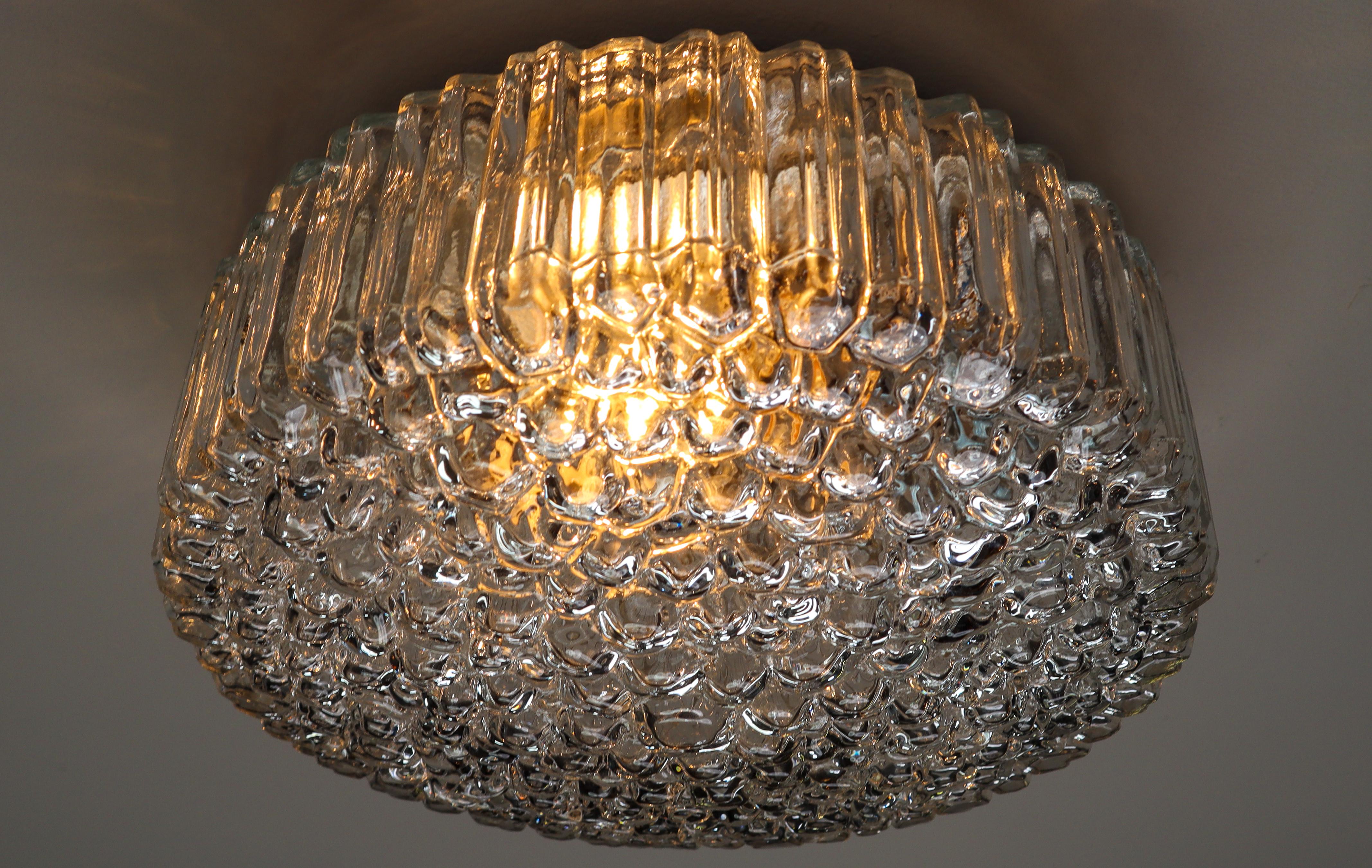 Gorgeous medium large flush mount ceiling light made of heavy textured clear iced glass by Glashütte Limburg made in Germany, 1960s. This midcentury vintage lamp illuminates beautifully, casting a warm light over a ceiling or wall. Very good vintage