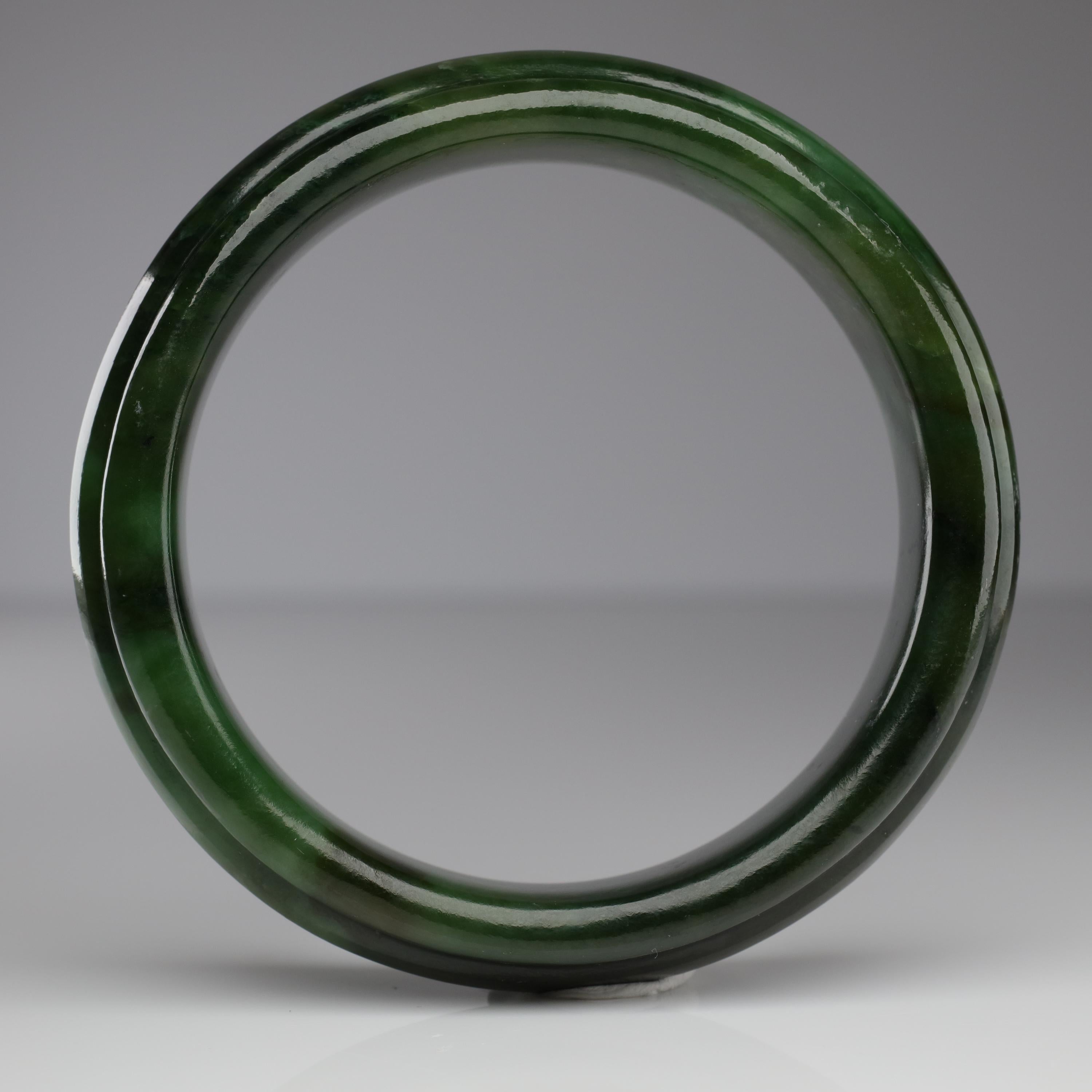 Here we have medium-large *heavy* bangle hand-carved from a solid piece of Wyoming nephrite jade. The unusual carving features a raised beveled 