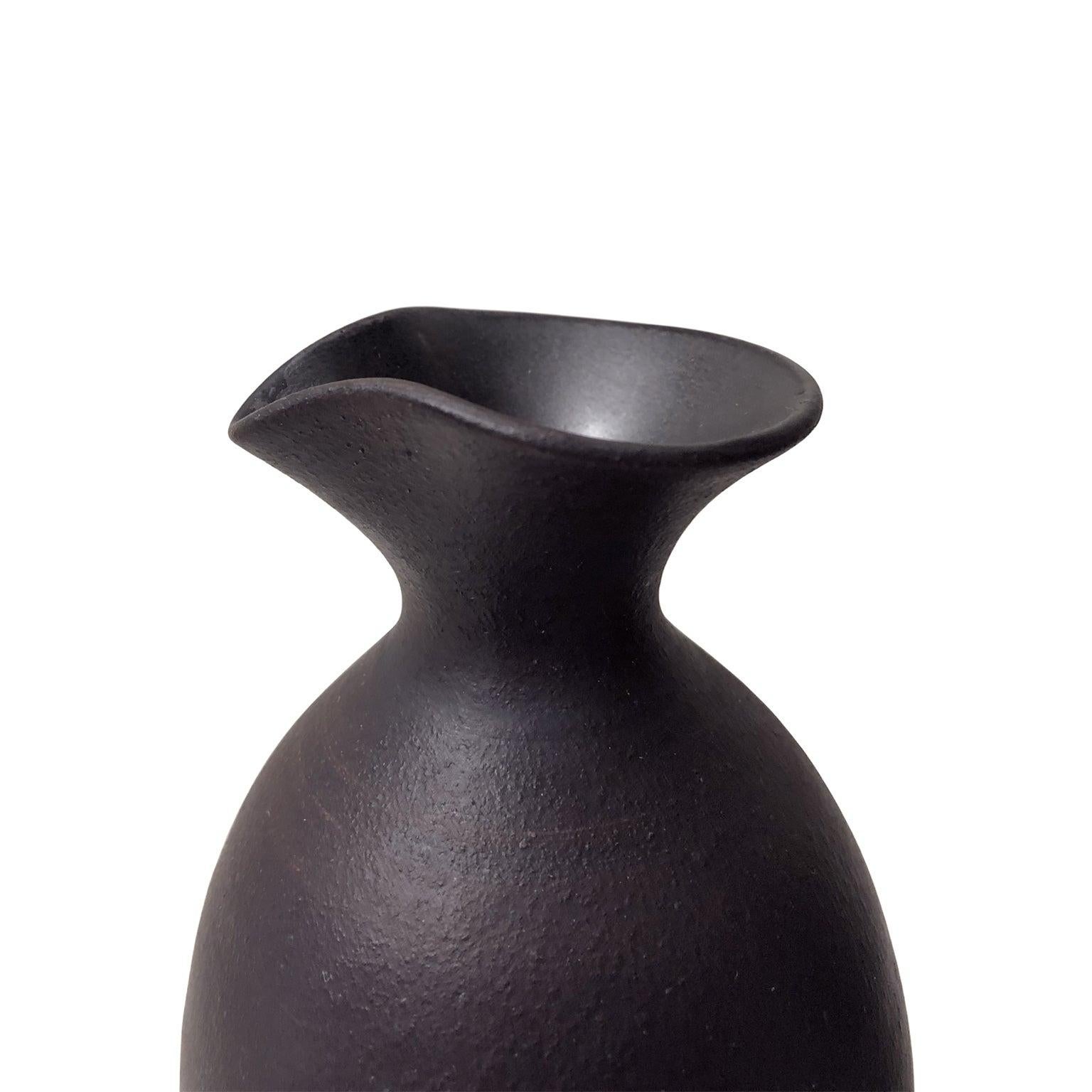 Medium matte black ceramic bottle vase with large spout neck and flared base by Sandi Fellman, 2019.
  