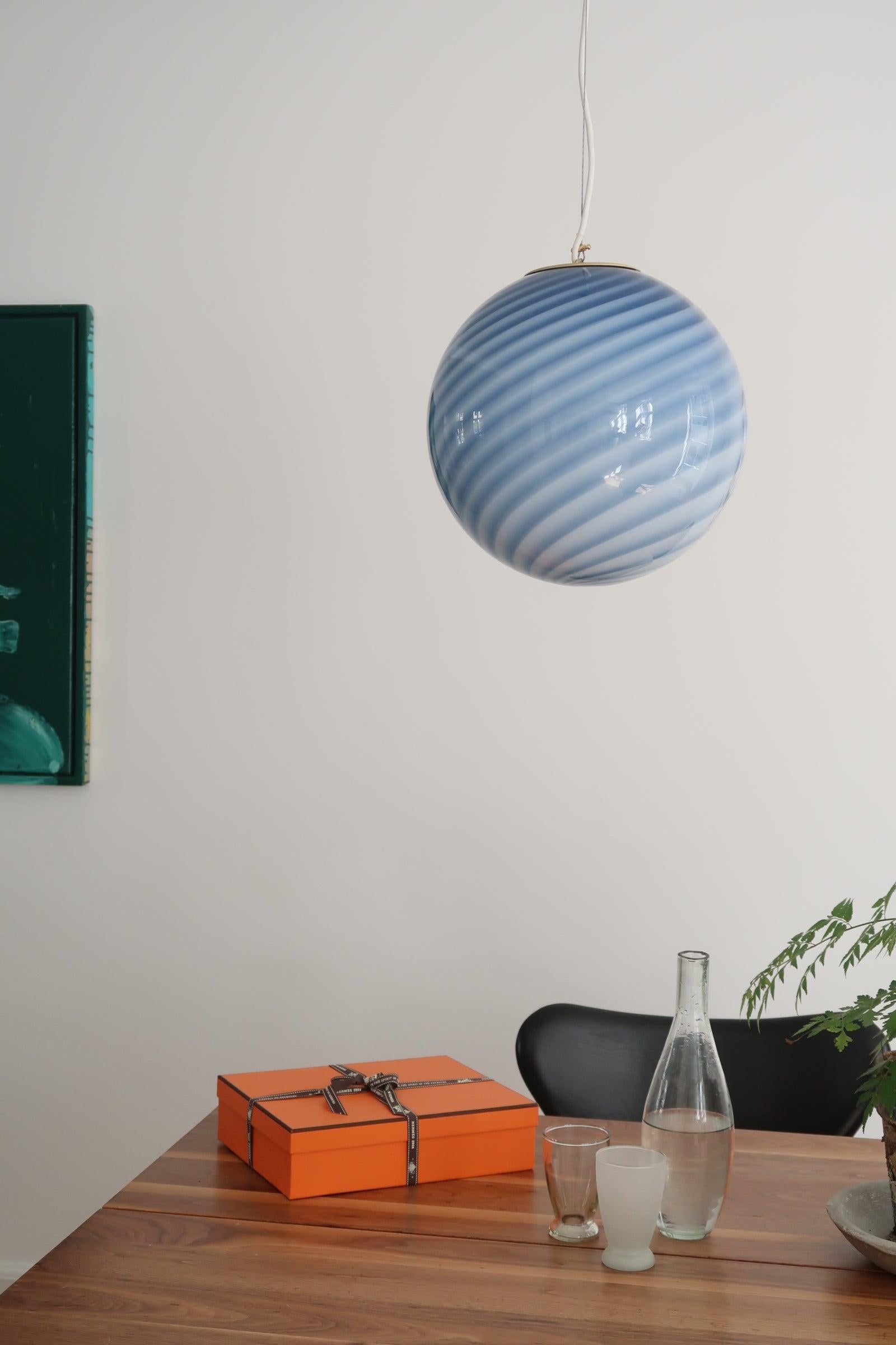 Medium Murano Vintage Candy pendant ceiling lamp in blue glass. Mouth-blown glass in round shape with swirl pattern. E27 socket. Comes with adjustable suspension. 
Handmade in Italy.
D:30 cm  

As it is mouth blown glass, the expression will differ