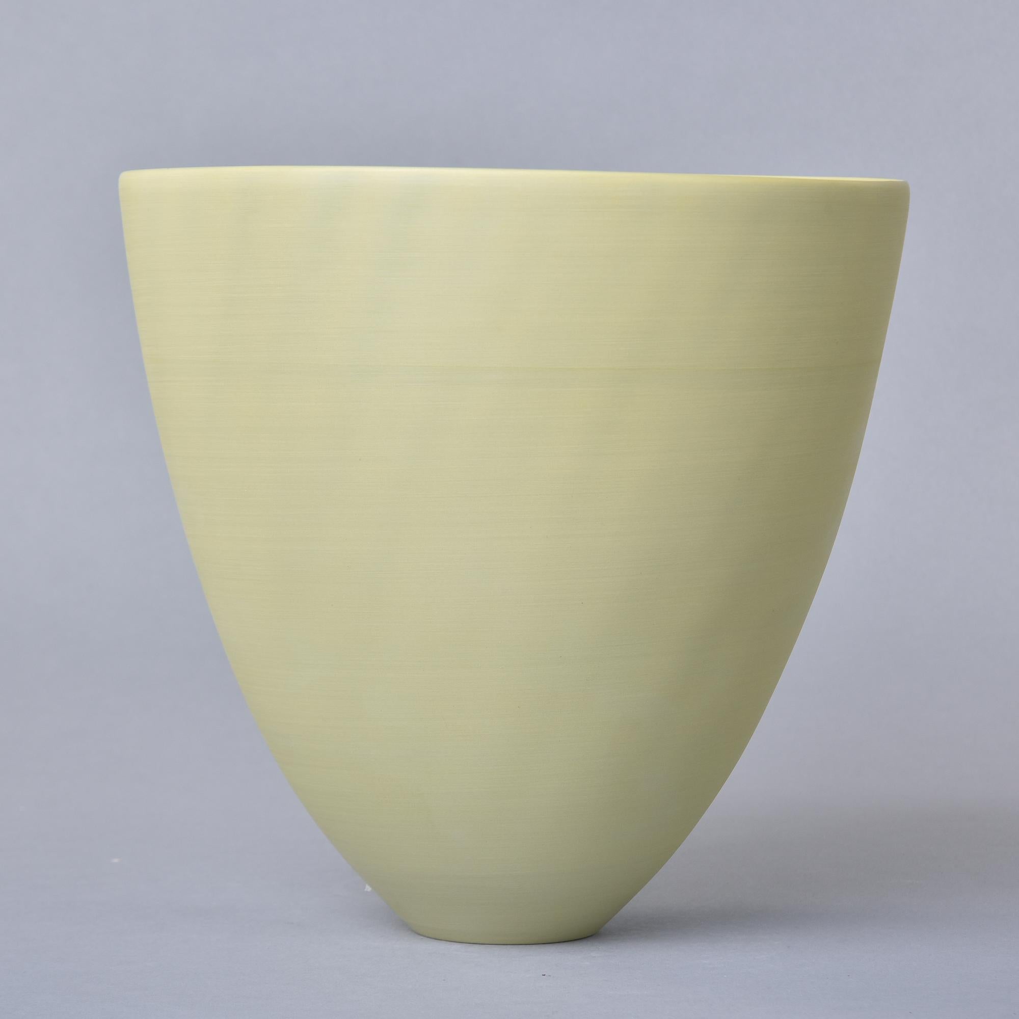 Nouveau et fabriqué à la main en Italie par Rina Menardi, ce bol ou vase en forme de coupe mesure un peu moins de 11 pouces de haut et est recouvert d'une glaçure vert pistache pâle. Forme épurée avec de fines parois en porcelaine émaillée et la