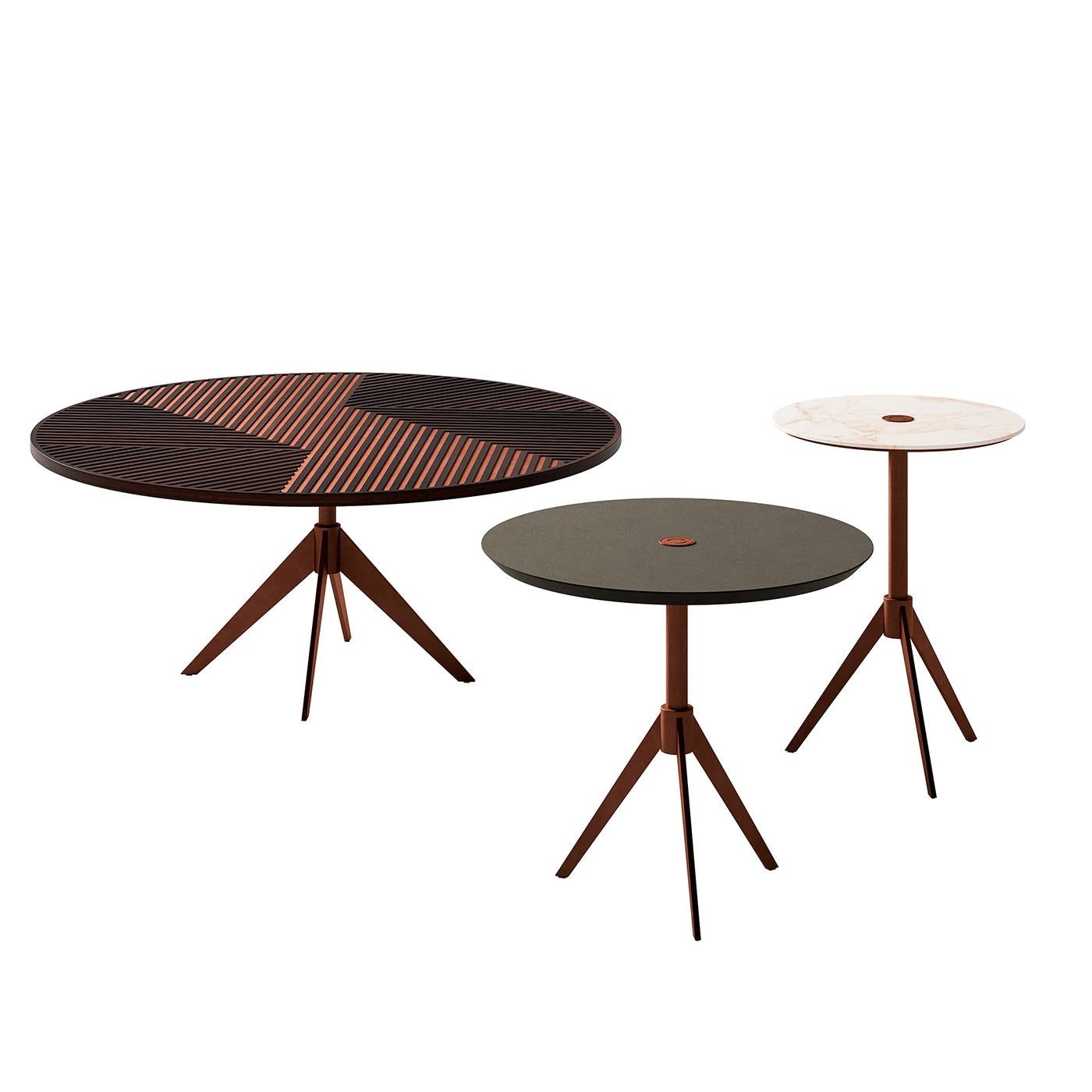 A simple and versatile construction that is captivating and bold, this coffee table boasts a sleek profile raised on a tripod-shaped metal base with the central rod extending through the round top. The brushed-copper finish of the base complements