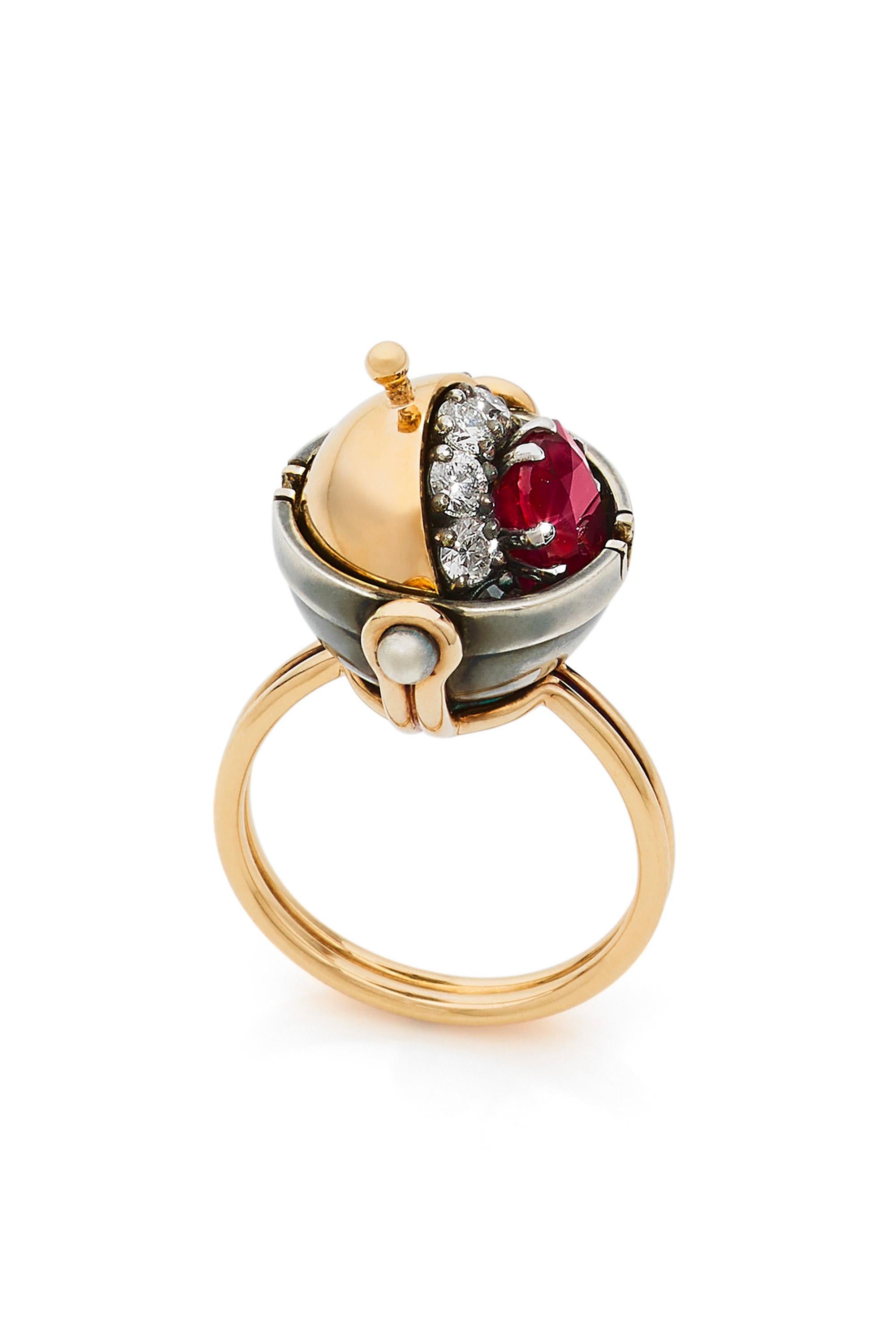 Gold and distressed silver ring.  Rotating sphere set with a star diamond revealing a cushion-cut ruby surrounded by diamonds.

Details:
Ruby : 1.6 cts, , 6.5x6.5
10 Diamonds : 0.92 cts 
18k Gold : 6.6g 
Distressed Silver : 5g 
Made in France