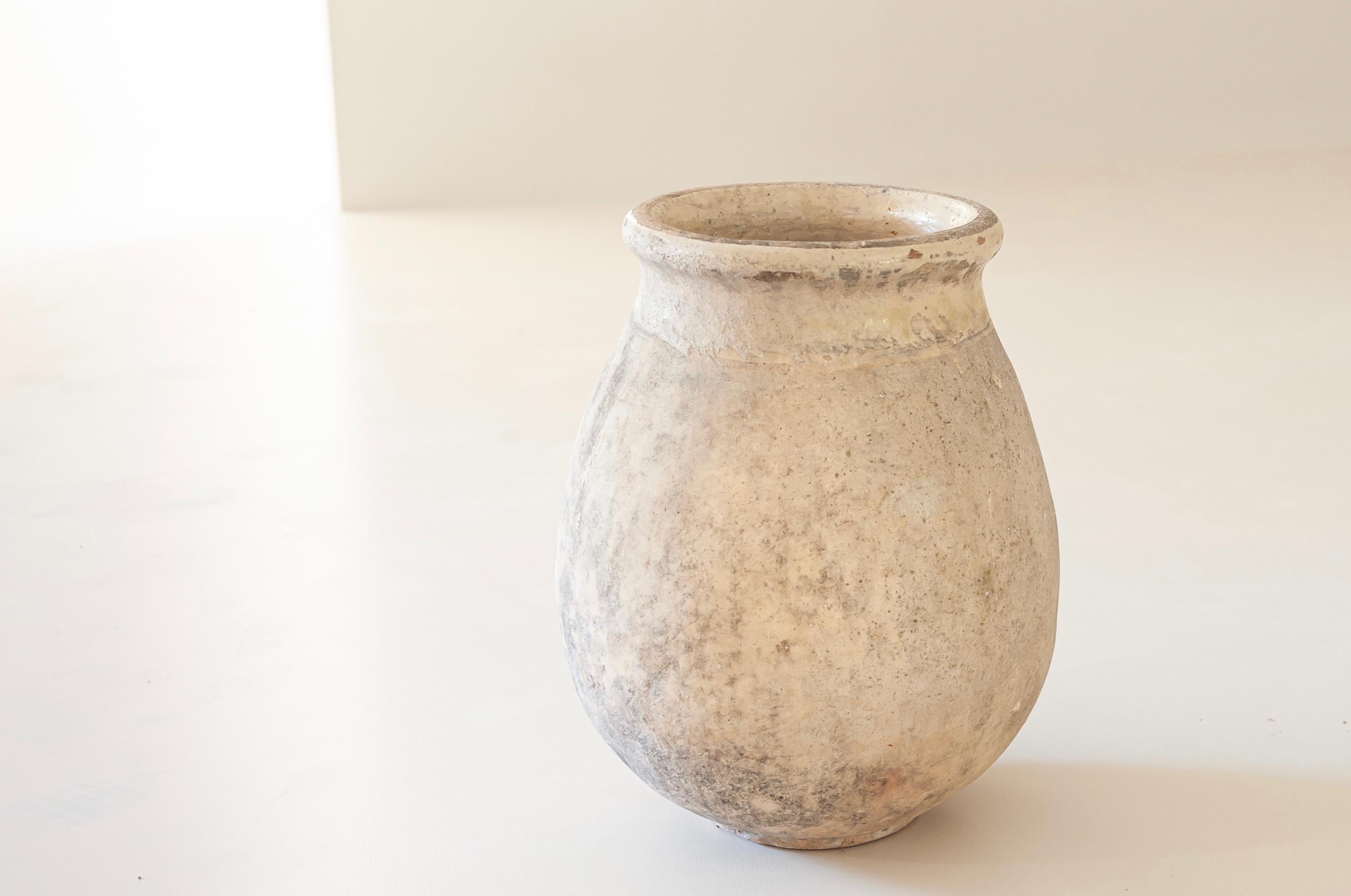 Beautiful original 19th century Ligurian olive jar with a charming aged patina and perfect proportions and measures for both an indoor and outdoor use.

Handcrafted using white soil and the ancient technique of rope thrown pottery, with an elegant