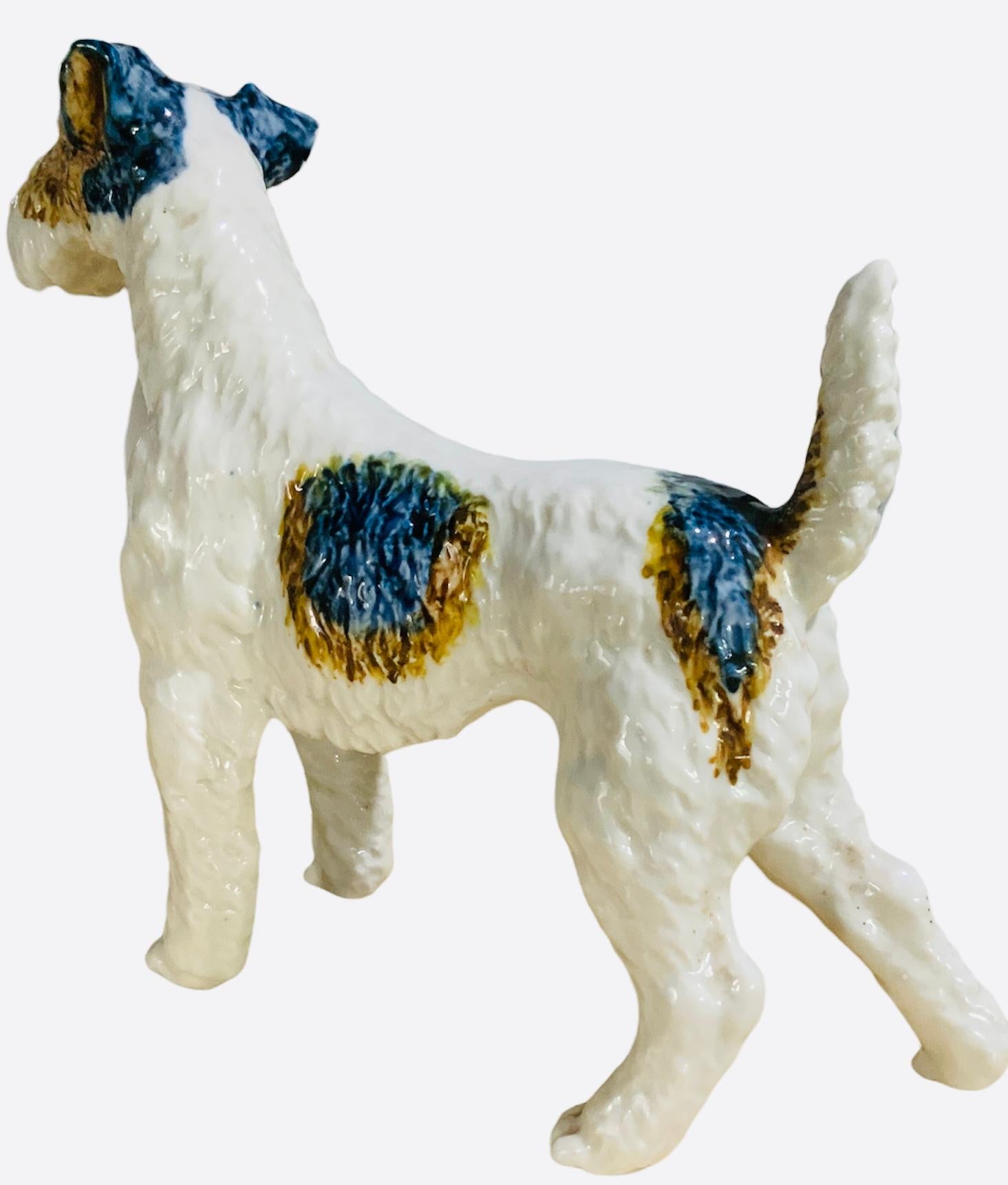 This is an adorable medium size glazed porcelain figurine of a Terrier dog. It is hand painted white and highlighted with yellow-brownish spots. Very well made. It doesn’t have any hallmark.