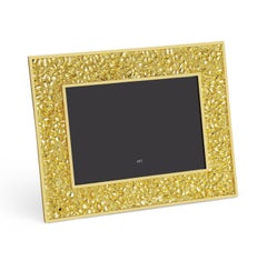 Cornice di medie dimensioni con motivo a melograno in metallo placcato oro.