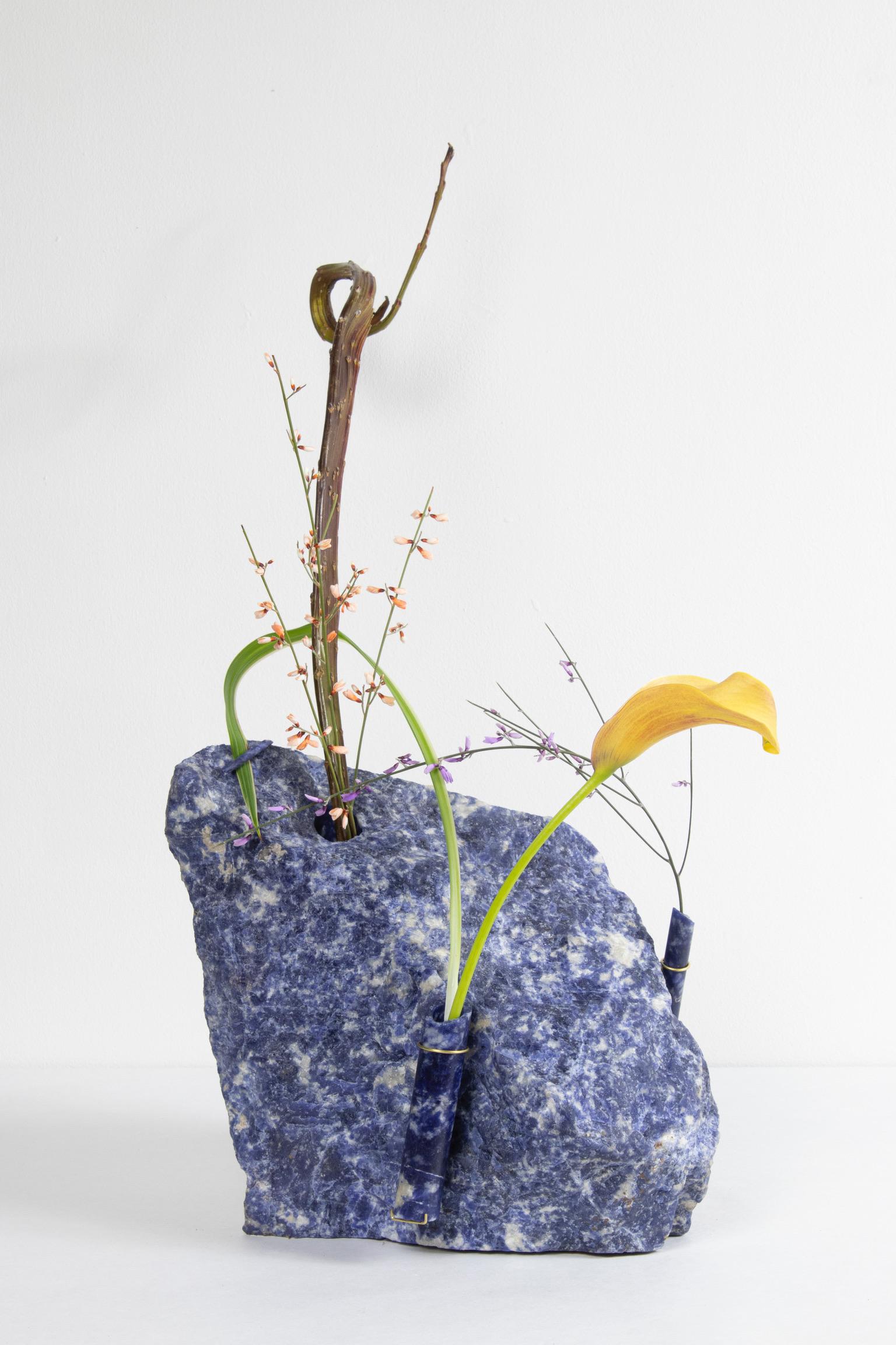 Medium Sodalite Flower Vessel by Studio DO
Dimensions: D 23 x W 16 x H 24 cm
Materials: Sodalite, brass.
15 kg.

Flowers are intrinsically connected with composition and earth.
Influenced by varied vessels from past to present such as the dutch