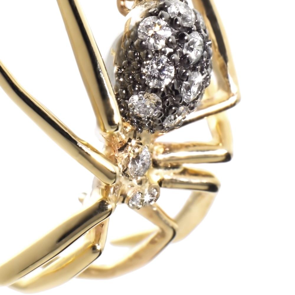 Prepare to be captivated by the allure of the Medium Spider Pendant Yellow Gold Black Rhodium Diamond, an enchanting embodiment of mystery and desire. With its glimmering belly and retractable legs, this enigmatic widow lies in wait, leaving us