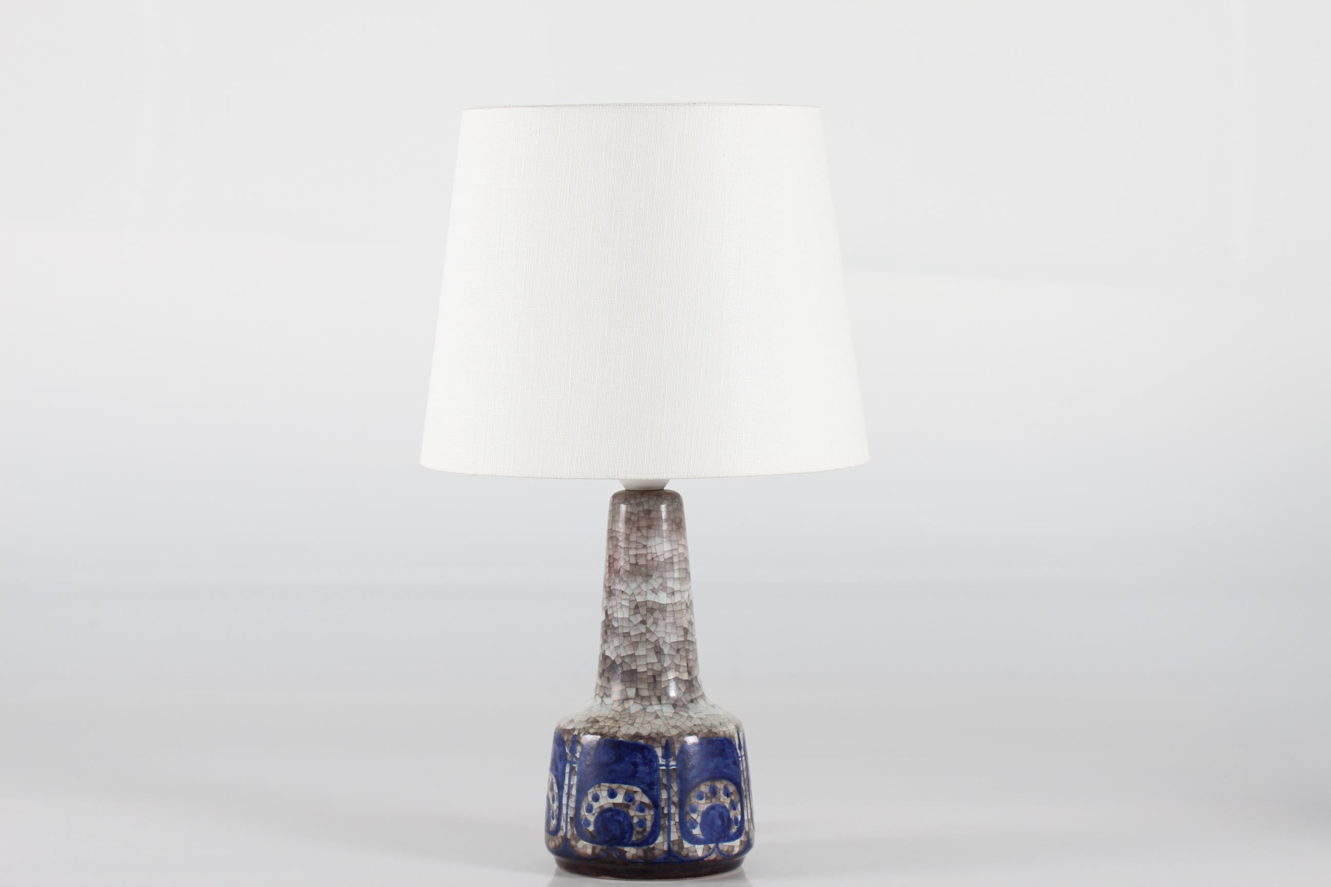 Dänische Tischleuchte aus der Mitte des Jahrhunderts von Marianne Starck für Michael Andersen & Søn.
Die Lampe ist mit der Persia-Glasur in Blau und Grau verziert, die ein abstraktes Blumendekor mit Anklängen an die islamische Kunst