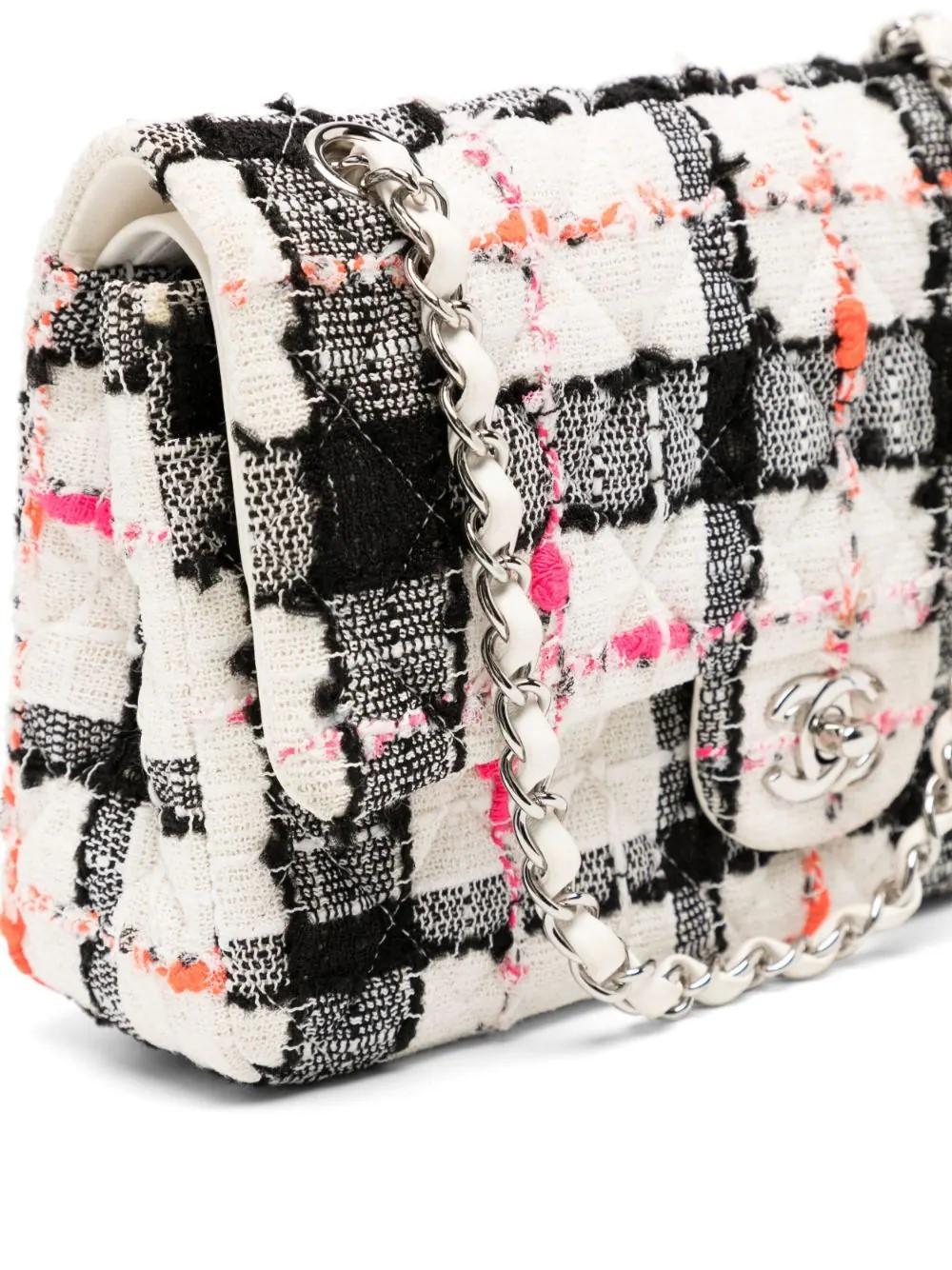 This medium tweed double flap from the Spring 2020 Ready-to-Wear collection features a tweed exterior and white calfskin interior with silver toned hardware and neon accents. These quality materials ensure a stylish and long-lasting addition to your